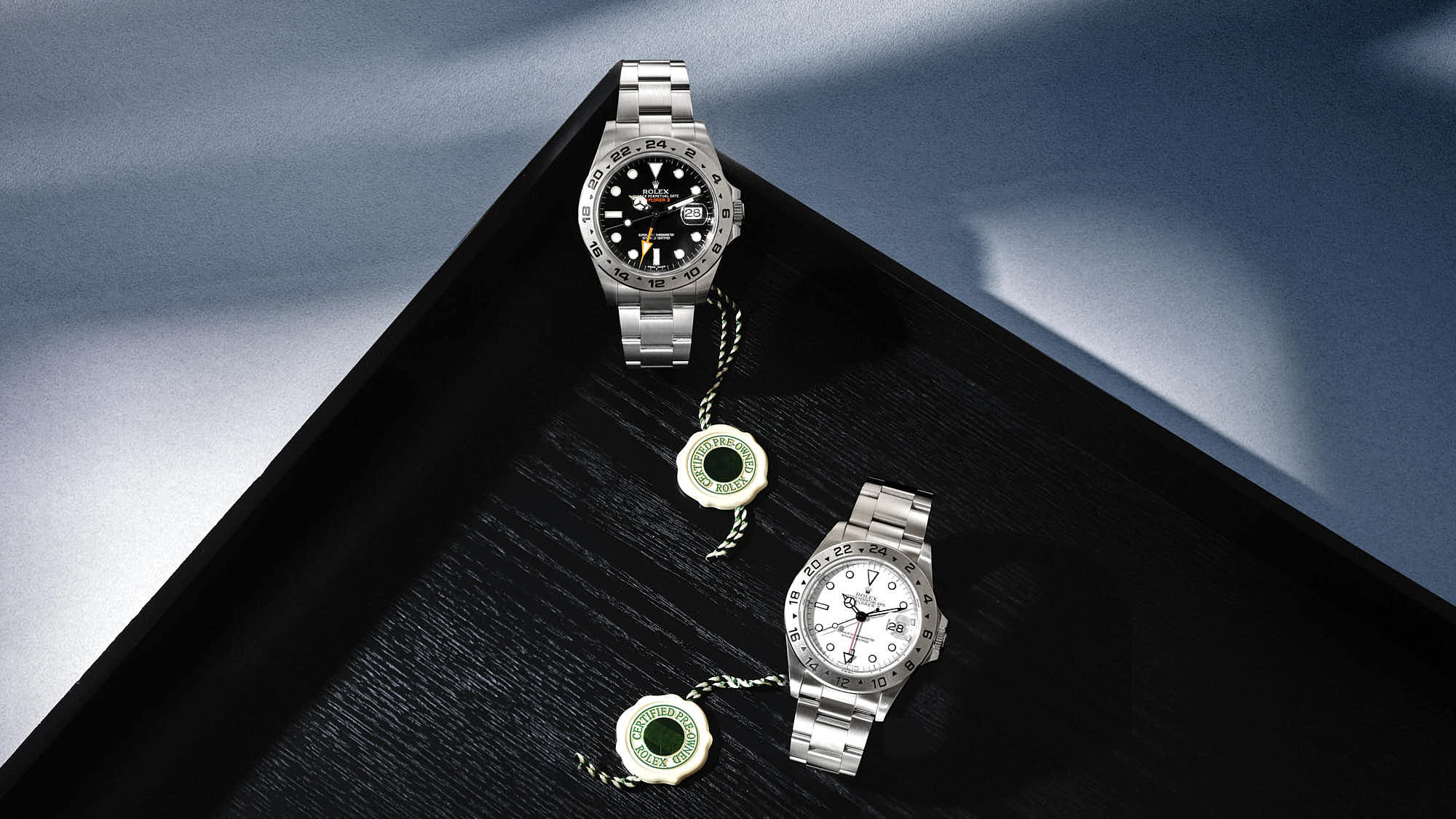 Luxury Rolex Explorer II watches on a stylish black surface.