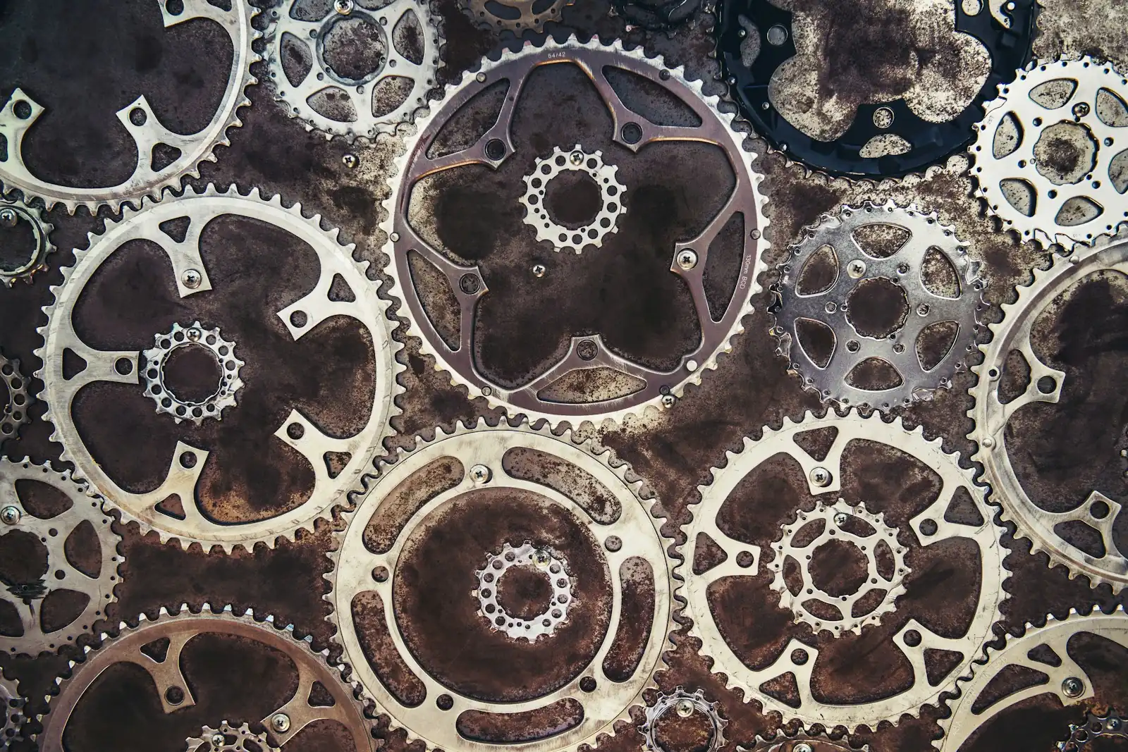 Overhead view of overlapping metal gears and chainrings of different sizes
