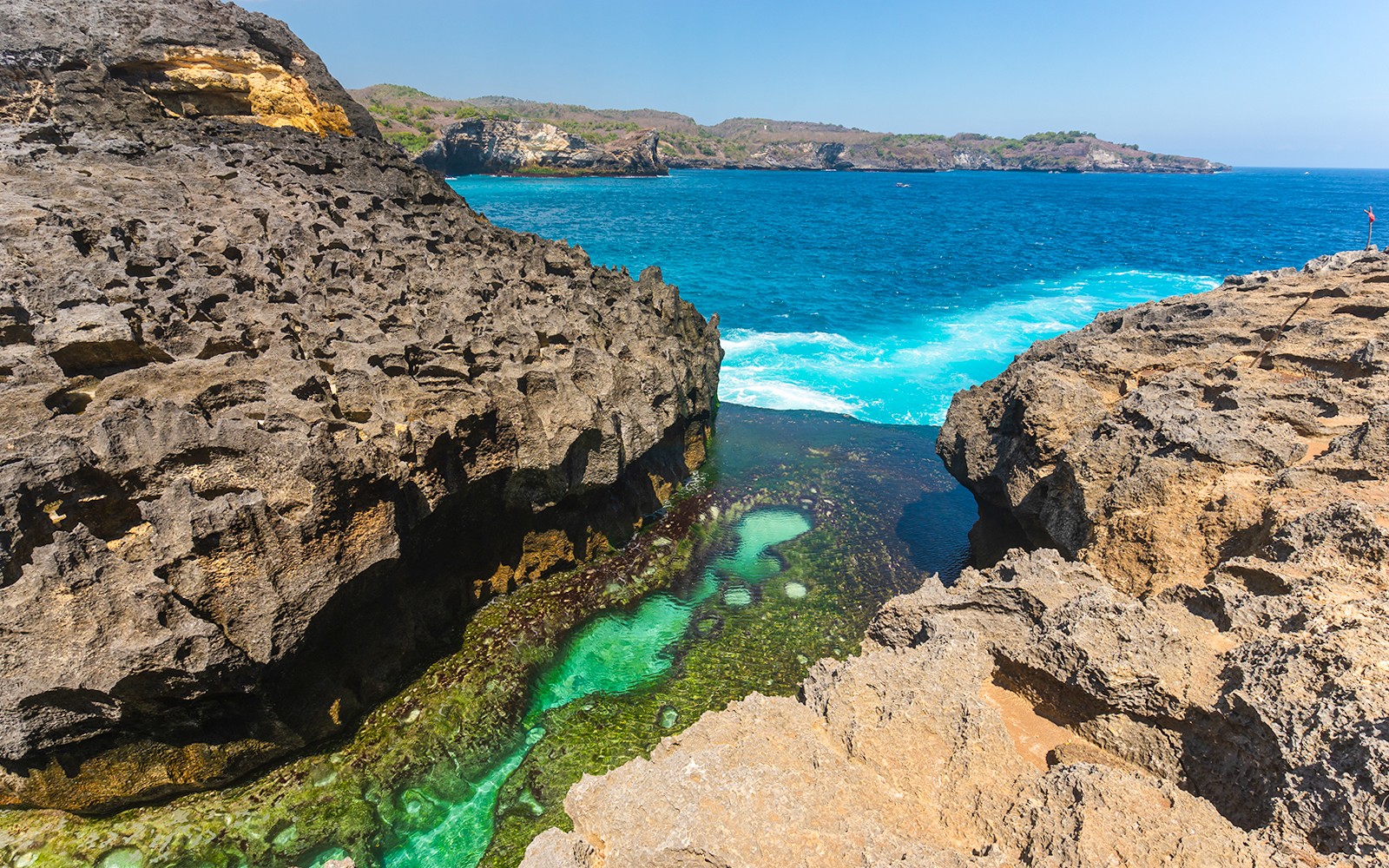 Piscina natural Angel's Billabong com águas cristalinas e falésias rochosas em Bali.