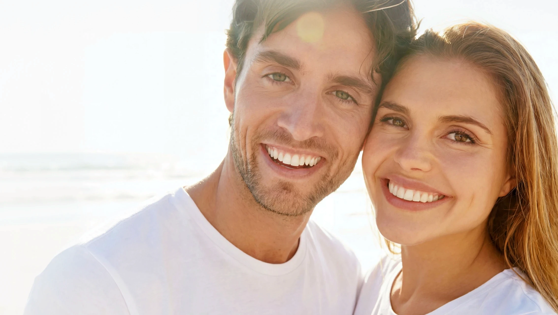 Kobieta z uśmiechem prezentująca efekty bondingu na swoich zębach.