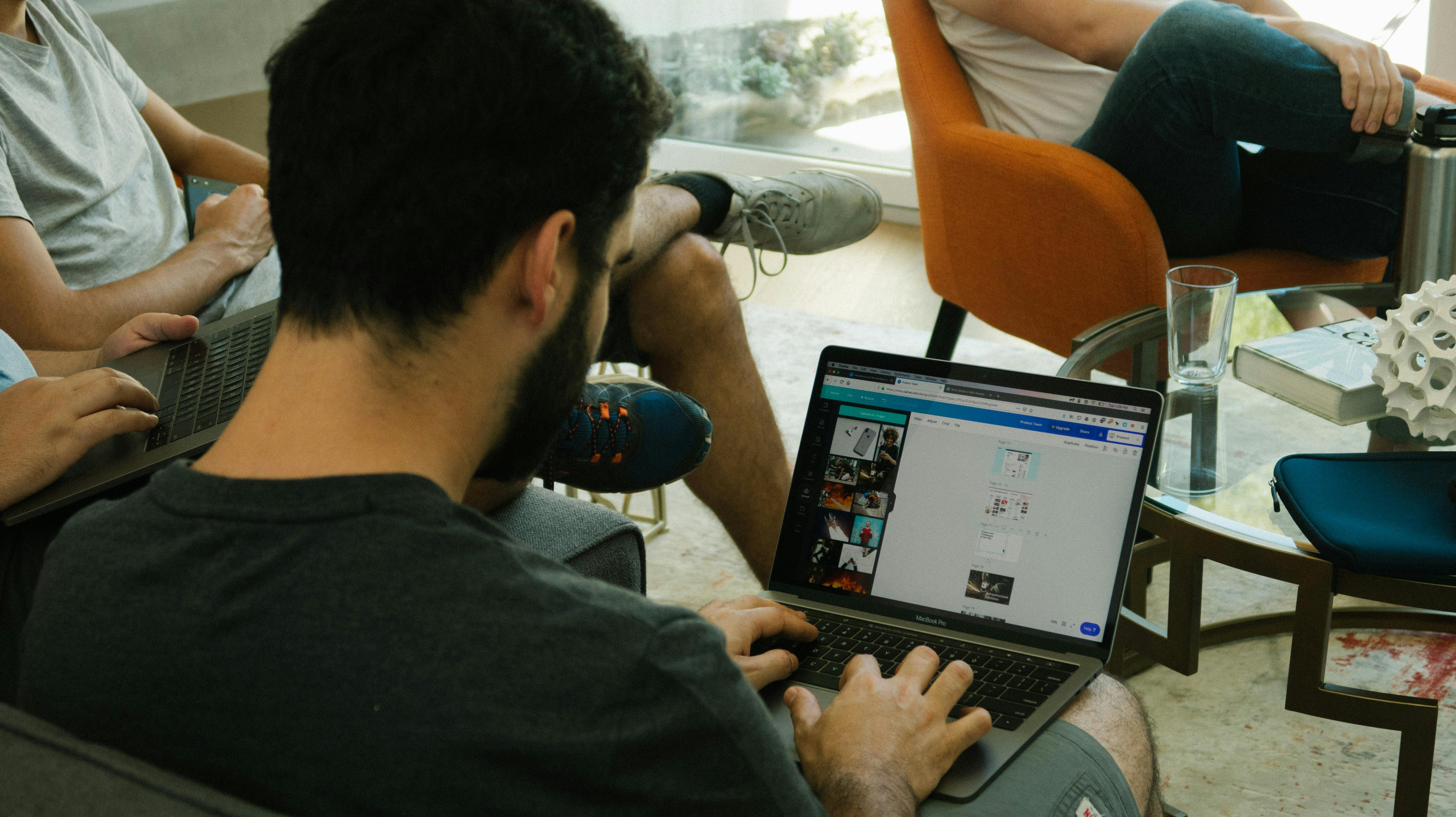 person typing on MacBook Pro on brown wooden table during daytime photo