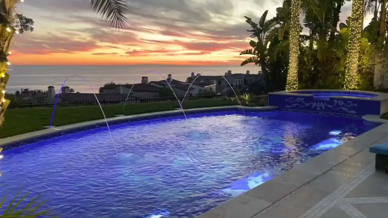 Hand-cut blue Greco Roman tile pool with sunset view in California.