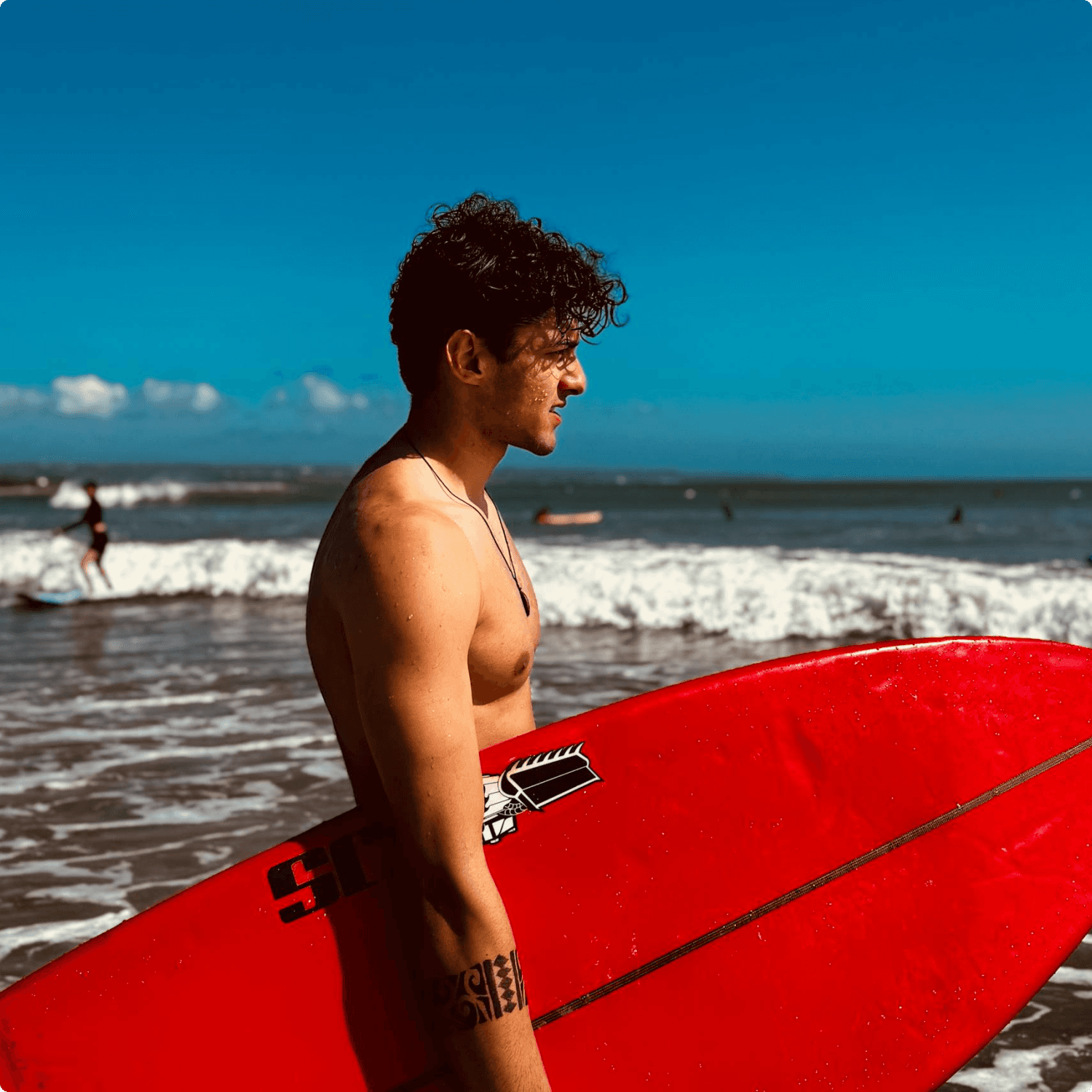 A man stading with Surfboard