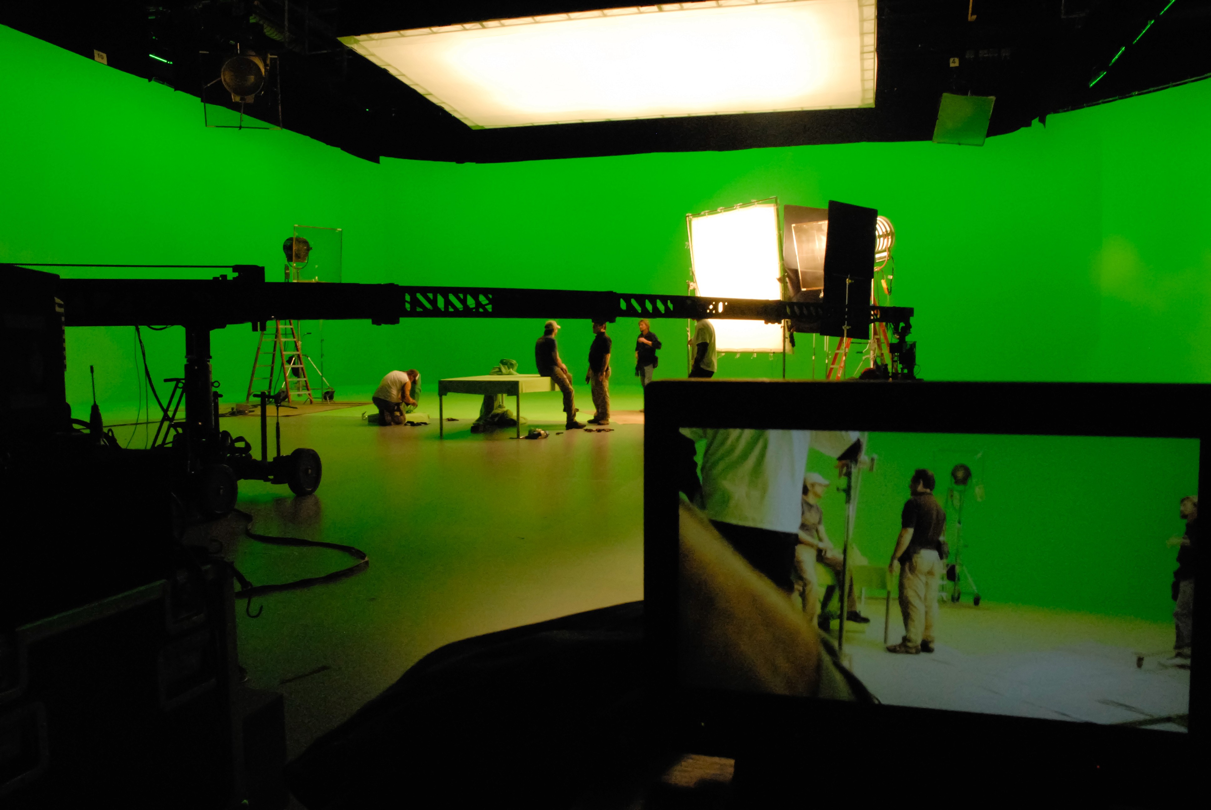 Film crew working on a green screen studio set with lighting rigs and VFX production setup, involving cinematographers, gaffers, and VFX artists.