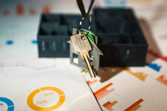 Llave con forma de vivienda sobre gráficos de solvencia con porcentajes de ingresos, simbolizando el estudio de solvencia del inquilino antes de contratar el seguro de impago de alquiler en Murcia.