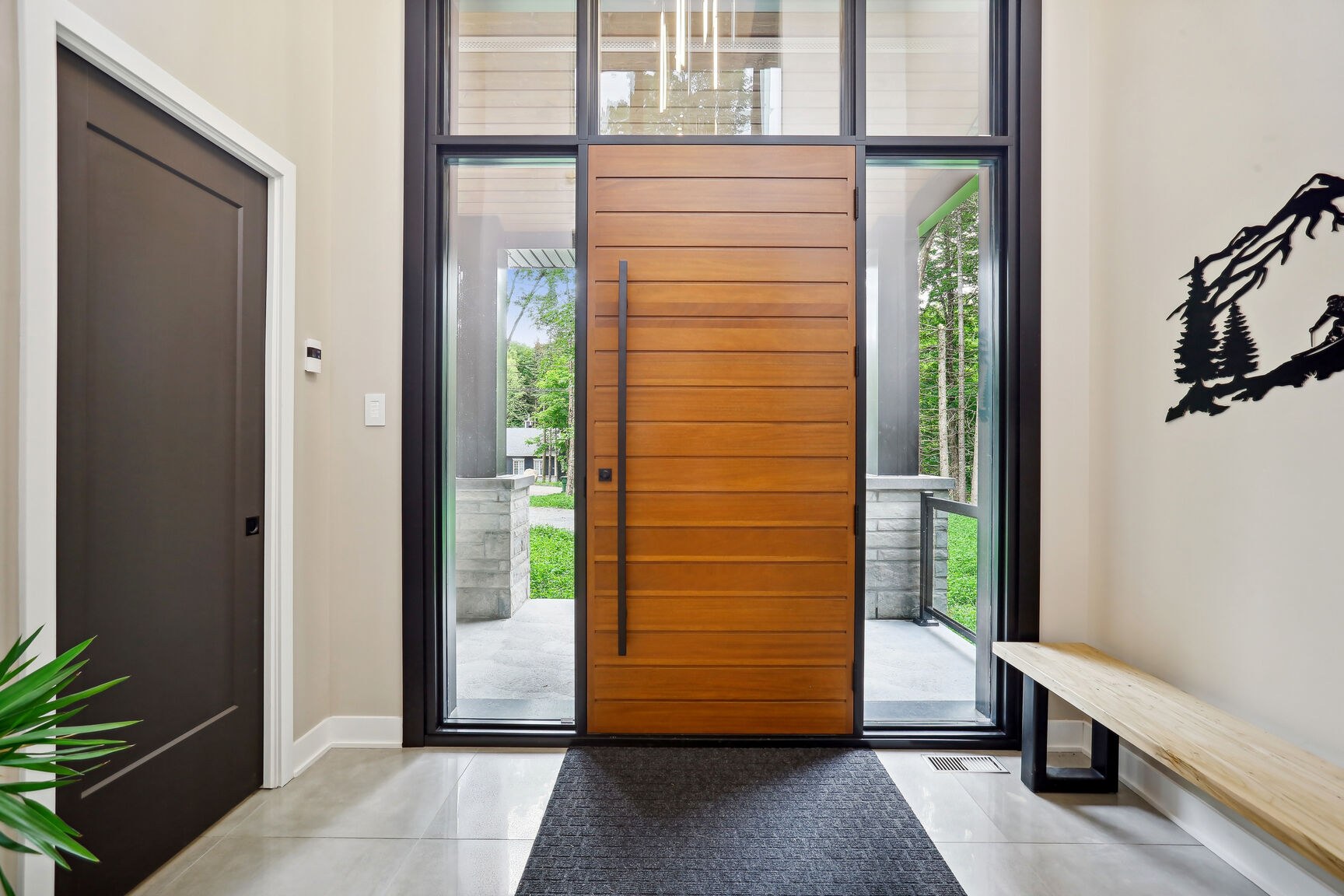 Porte d'entrée de pleine hauteur avec imposte vitrée, lumière naturelle.