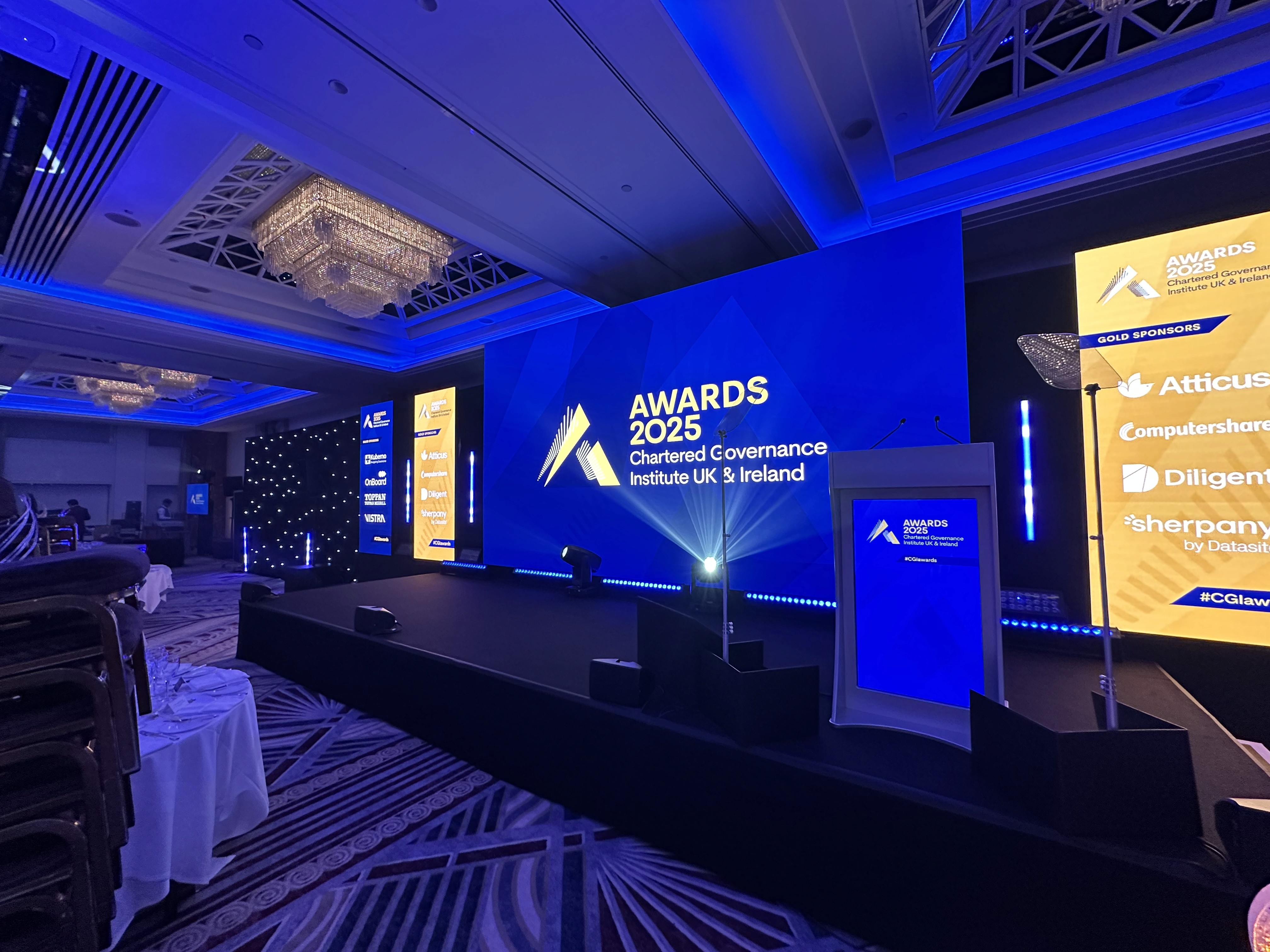 Wide view of the CGI Awards 2025 stage at Royal Lancaster London with central LED wall, sponsor totems and digital lectern.