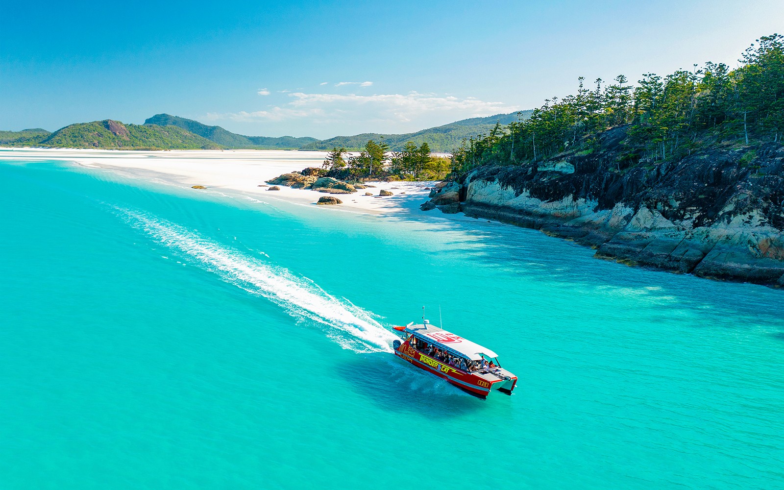 שייט בסירת ת'אנדרקט במים טורקיזיים ליד חוף וויטסנדיי.