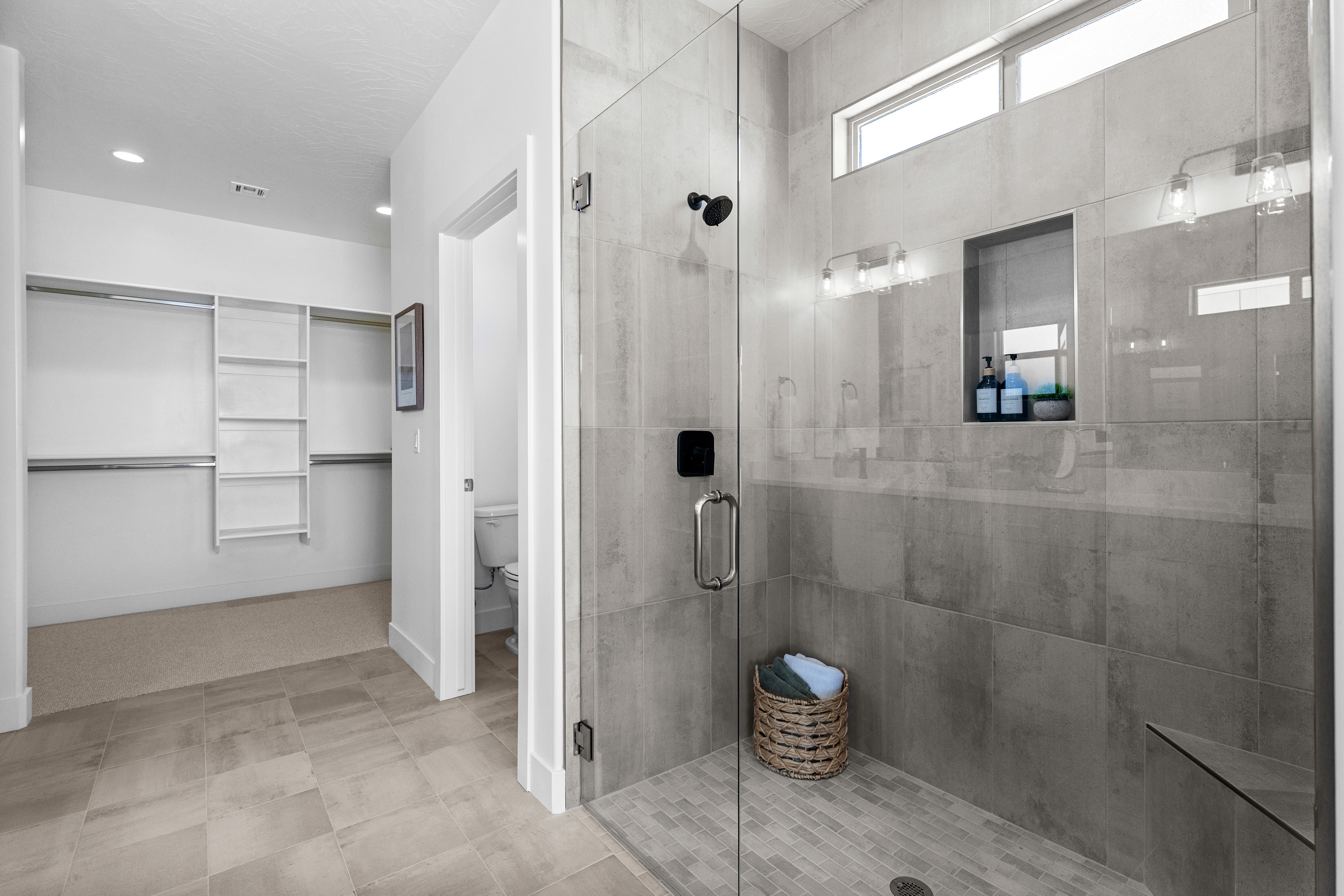Master shower in The Nest at Falcon Ridge custom home, with tiled walls and glass enclosure.