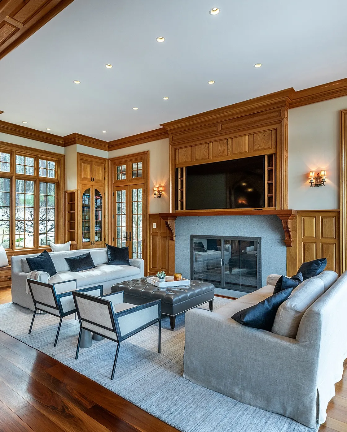 Warm living area with a stone fireplace, wooden beams, and comfortable seating arranged around a coffee table.