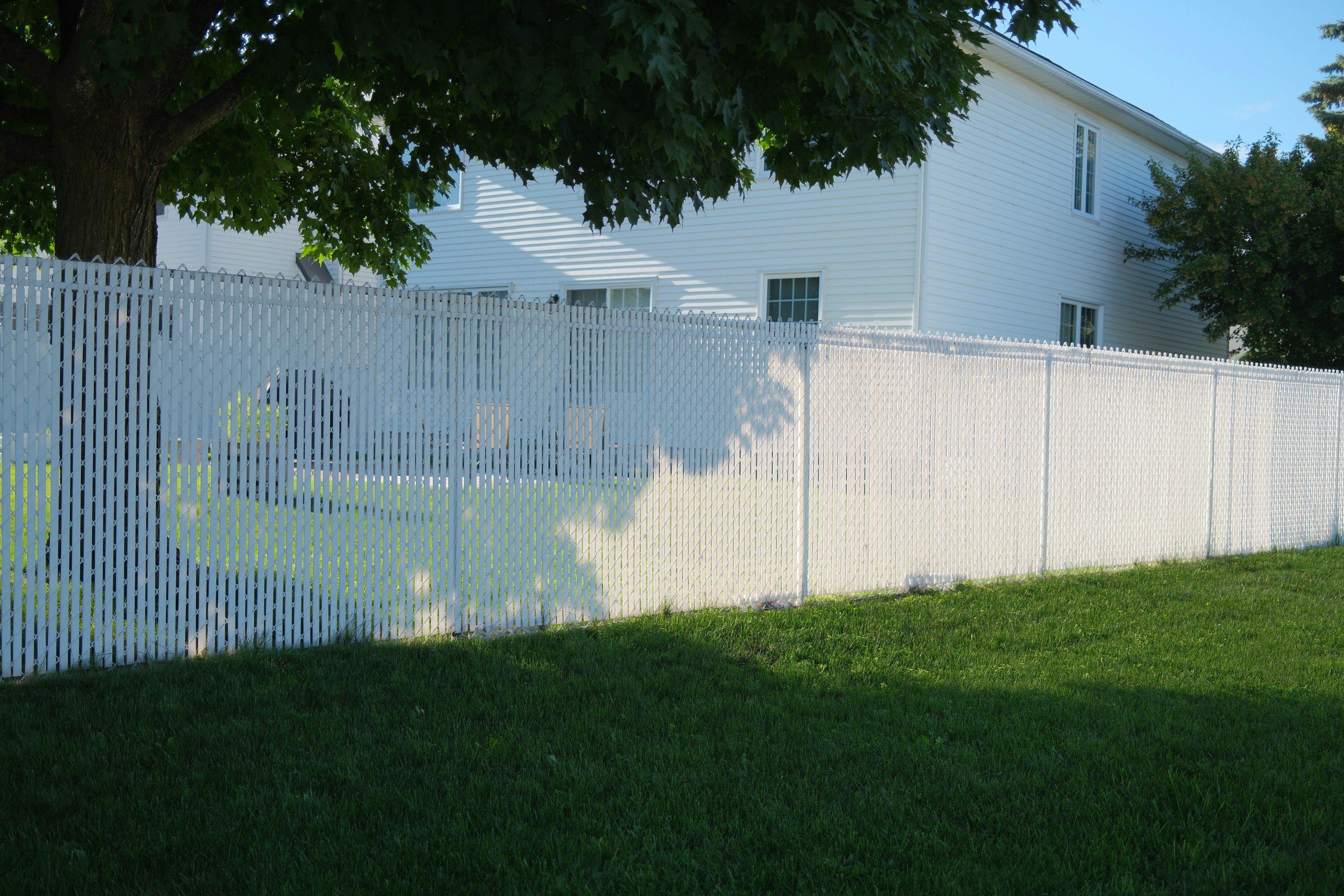 A white fence with a house in the background