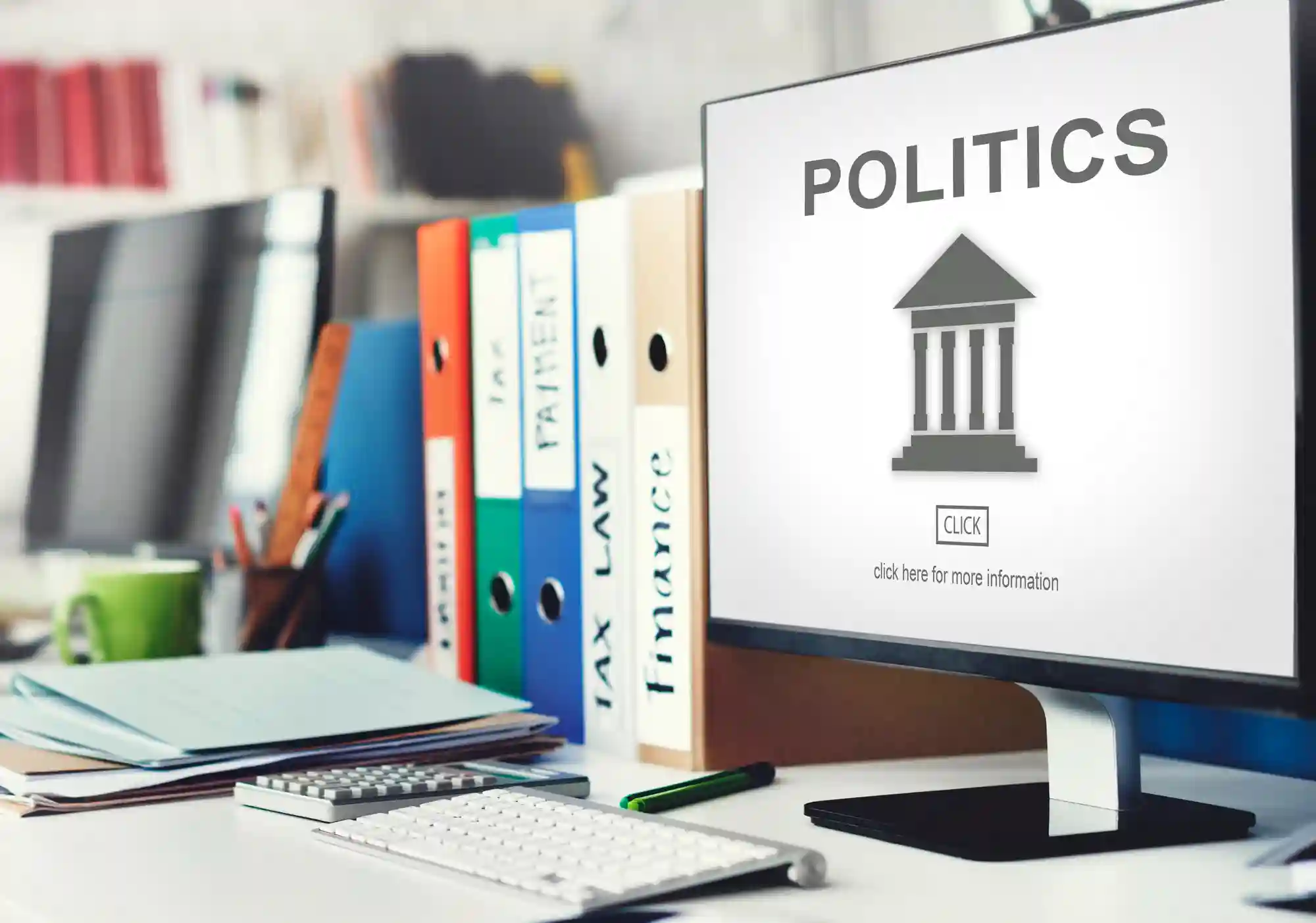 A computer monitor displaying "Politics" alongside legal files, representing the intersection of tech policy and government regulatory oversight.d