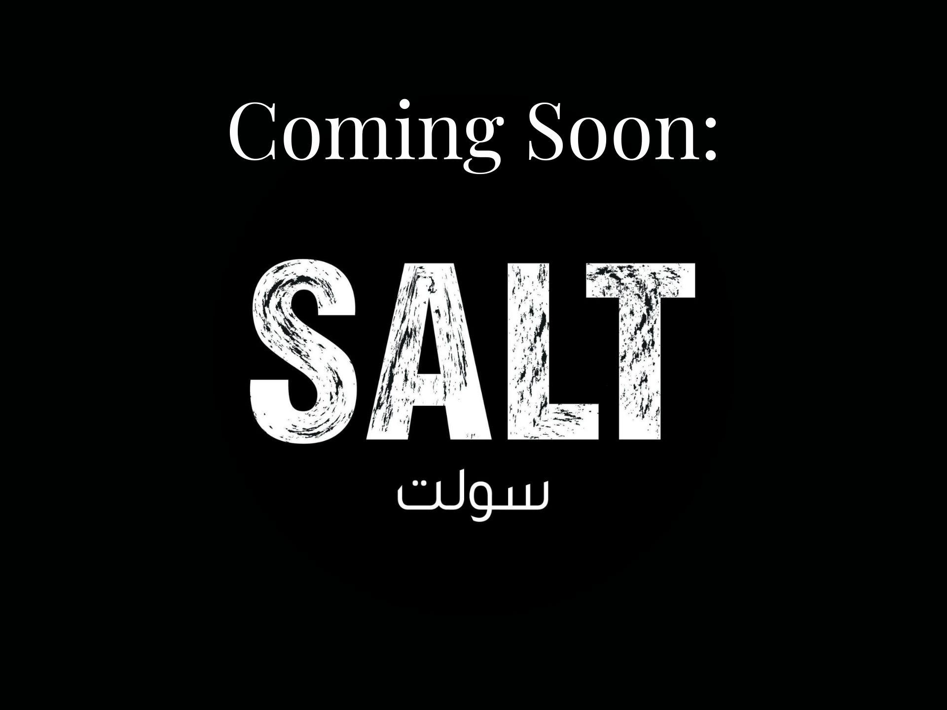 A sophisticated lounge terrace with curved white stucco walls, stone seating, and arched cutouts perfectly framing an unobstructed ocean sunset.