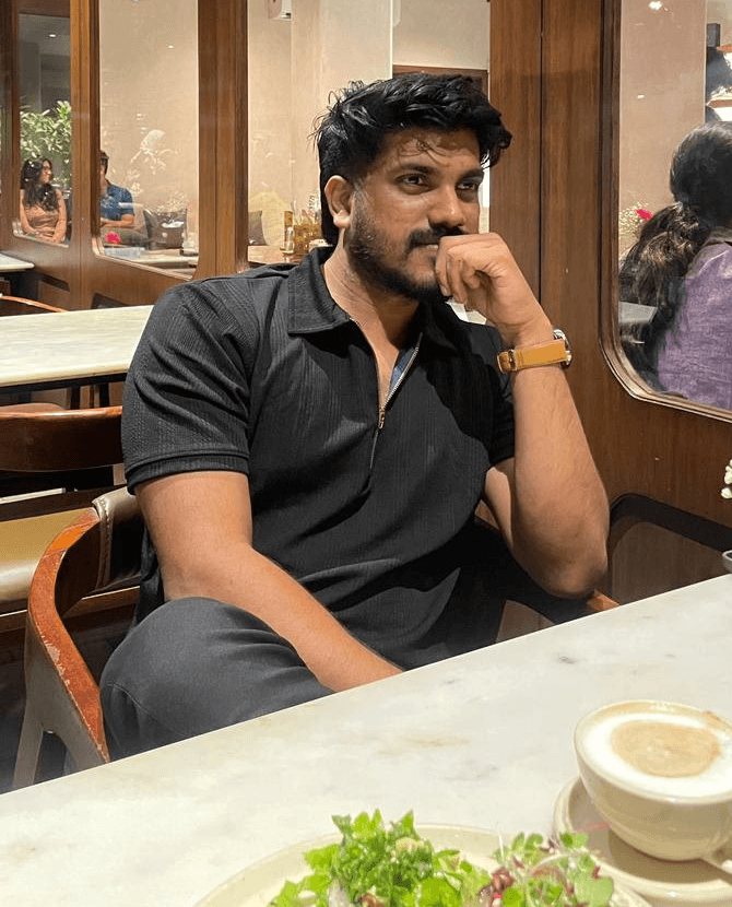 man sitting near gray steel roller shutters during daytime