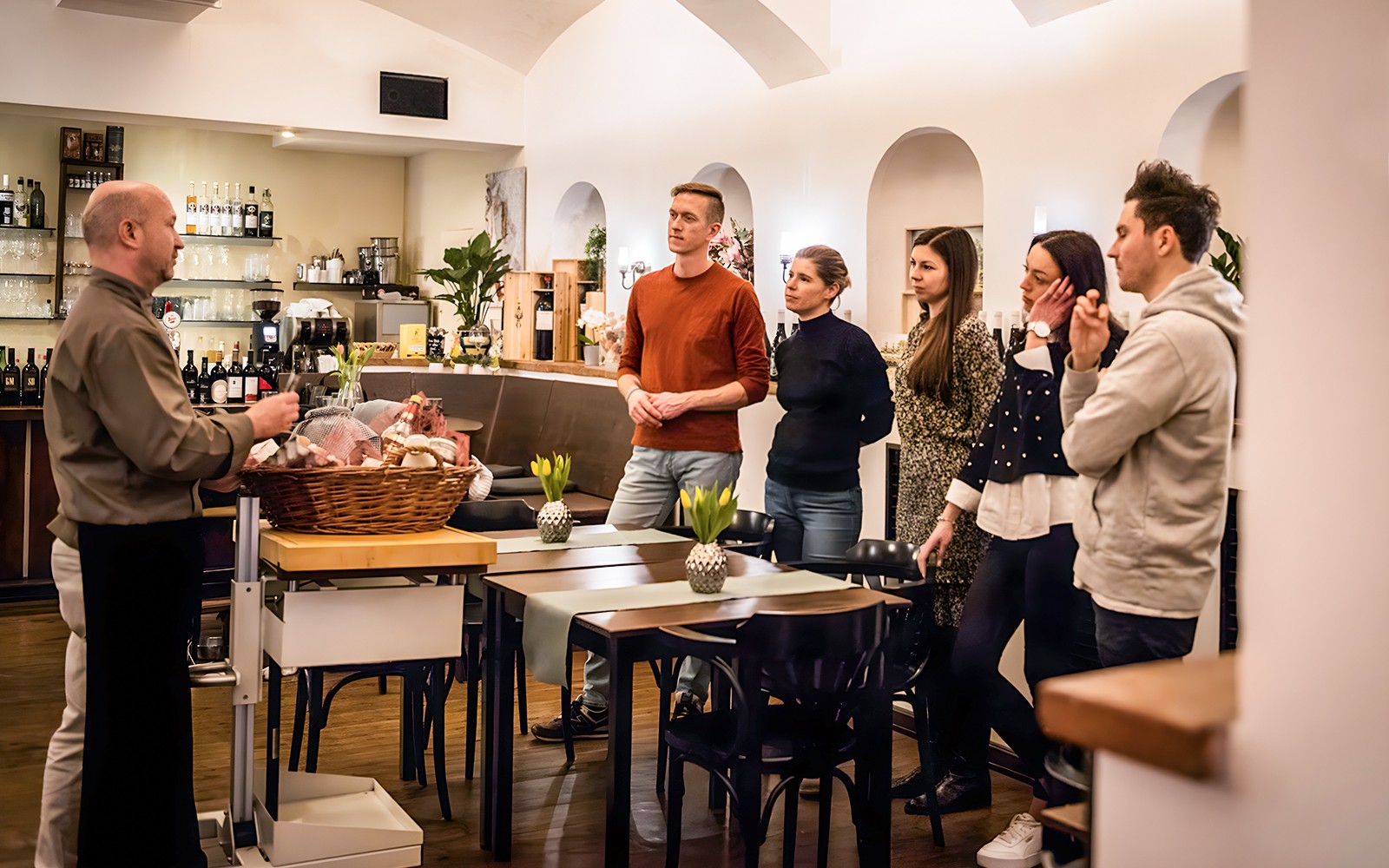 Chef explaining Kaiserschmarrn preparation to group in cooking class.