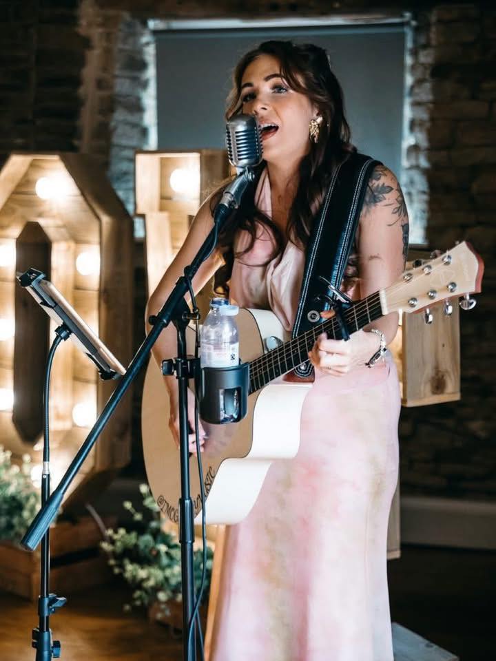 Singer performing on the guitar at a mic stand