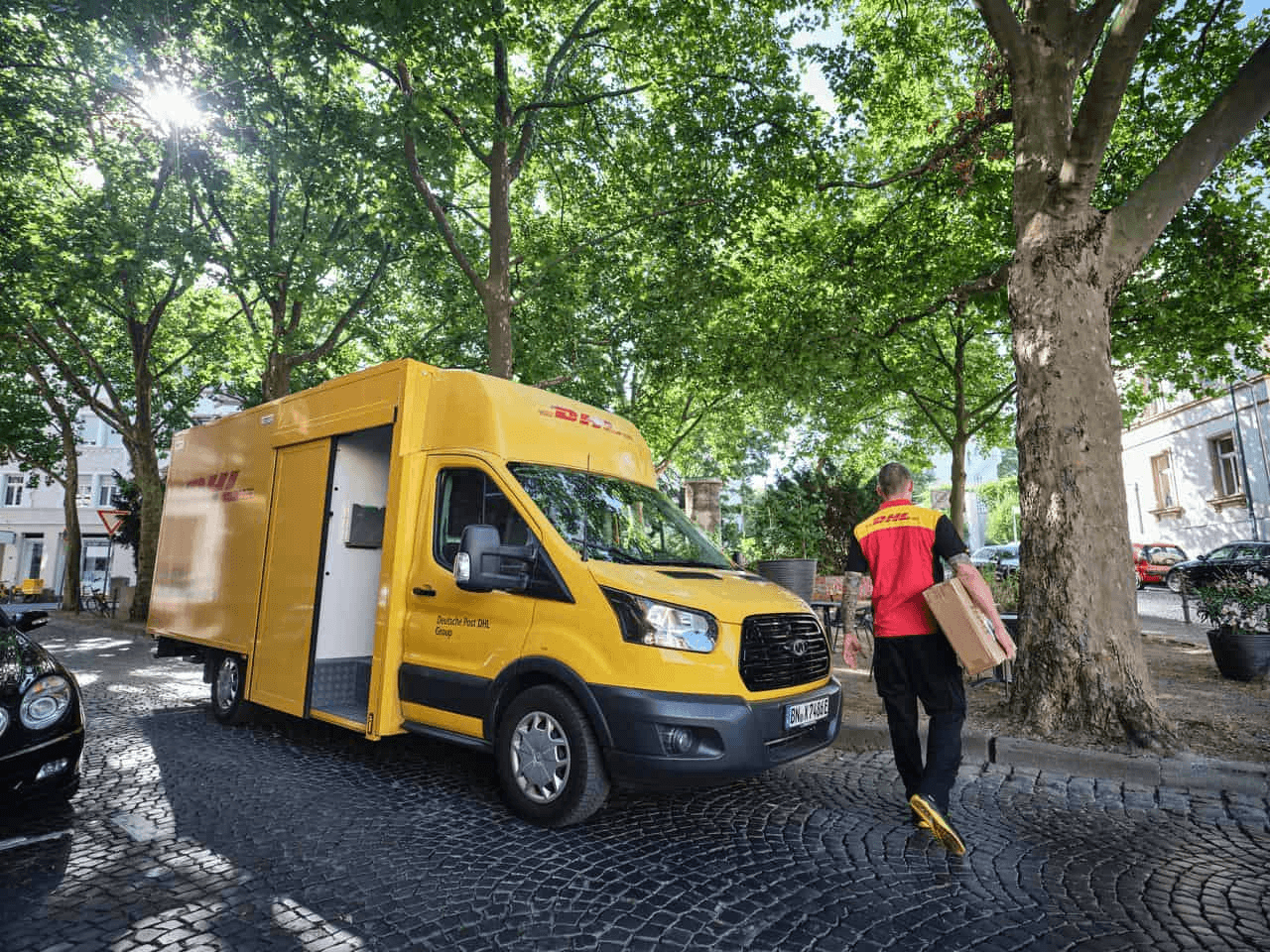 DHL van delivery with person holding parcel