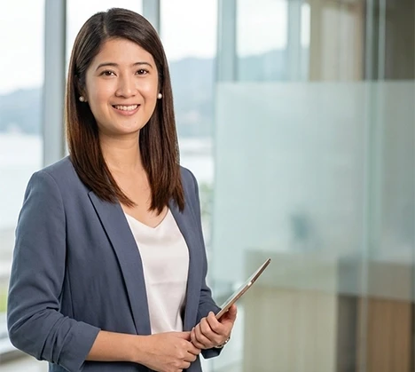 Smiling business professional holding a tablet in a modern office