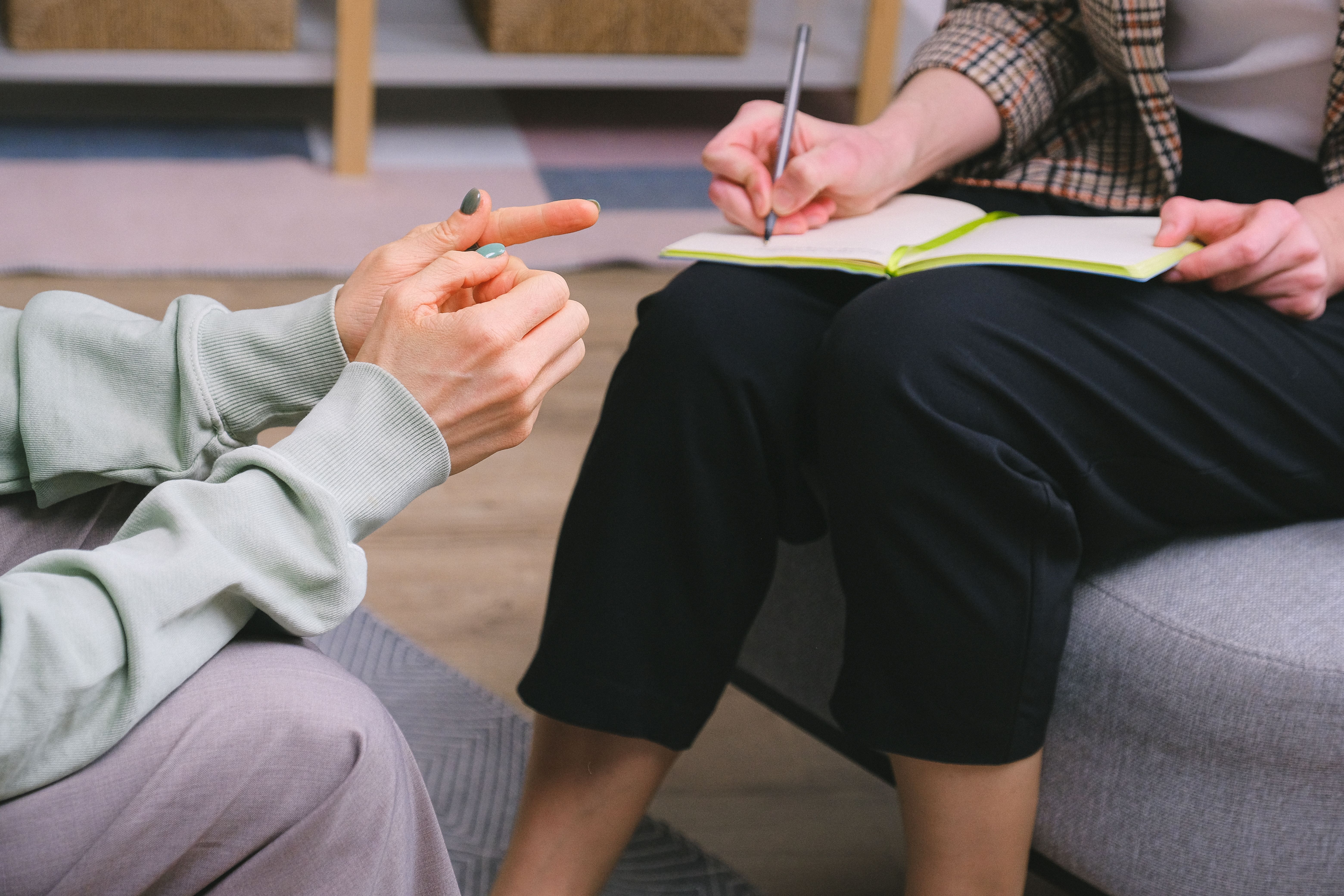 Therapist taking notes during an in-person therapy session