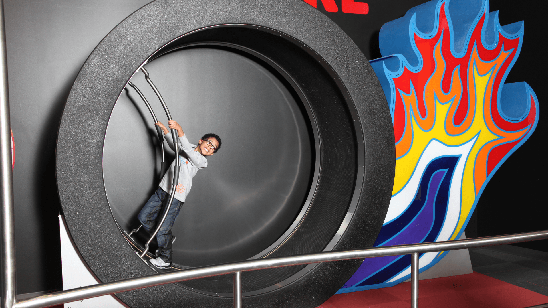 A young boy smiles as he races on the Wheel of Fire.