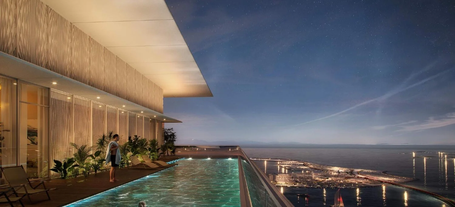 Private infinity pool overlooking the ocean at night. Modern luxury property presented by your real estate expert.