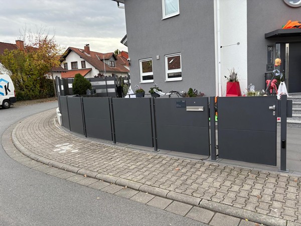 Gartenzaun und Tor für ein Einfamilienhaus in Dunkelgrau.