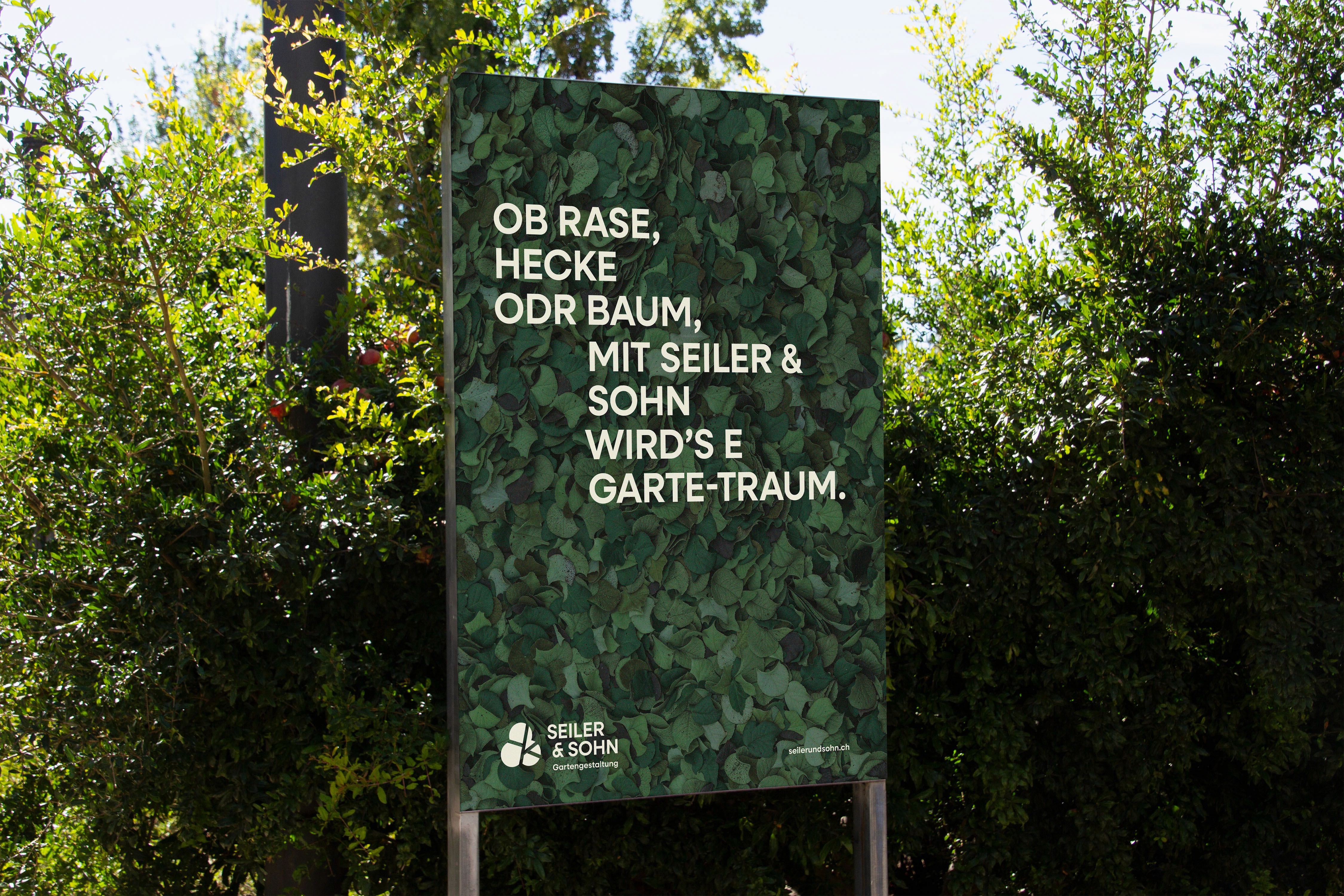 Grossformatiges Werbeplakat mit Eukalyptus-Blättern als Hintergrund und dem Schweizerdeutsch-Slogan OB RASE, HECKE ODR BAUM, MIT SEILER & SOHN WIRD'S E GARTE-TRAUM. – unten das Seiler & Sohn Logo.