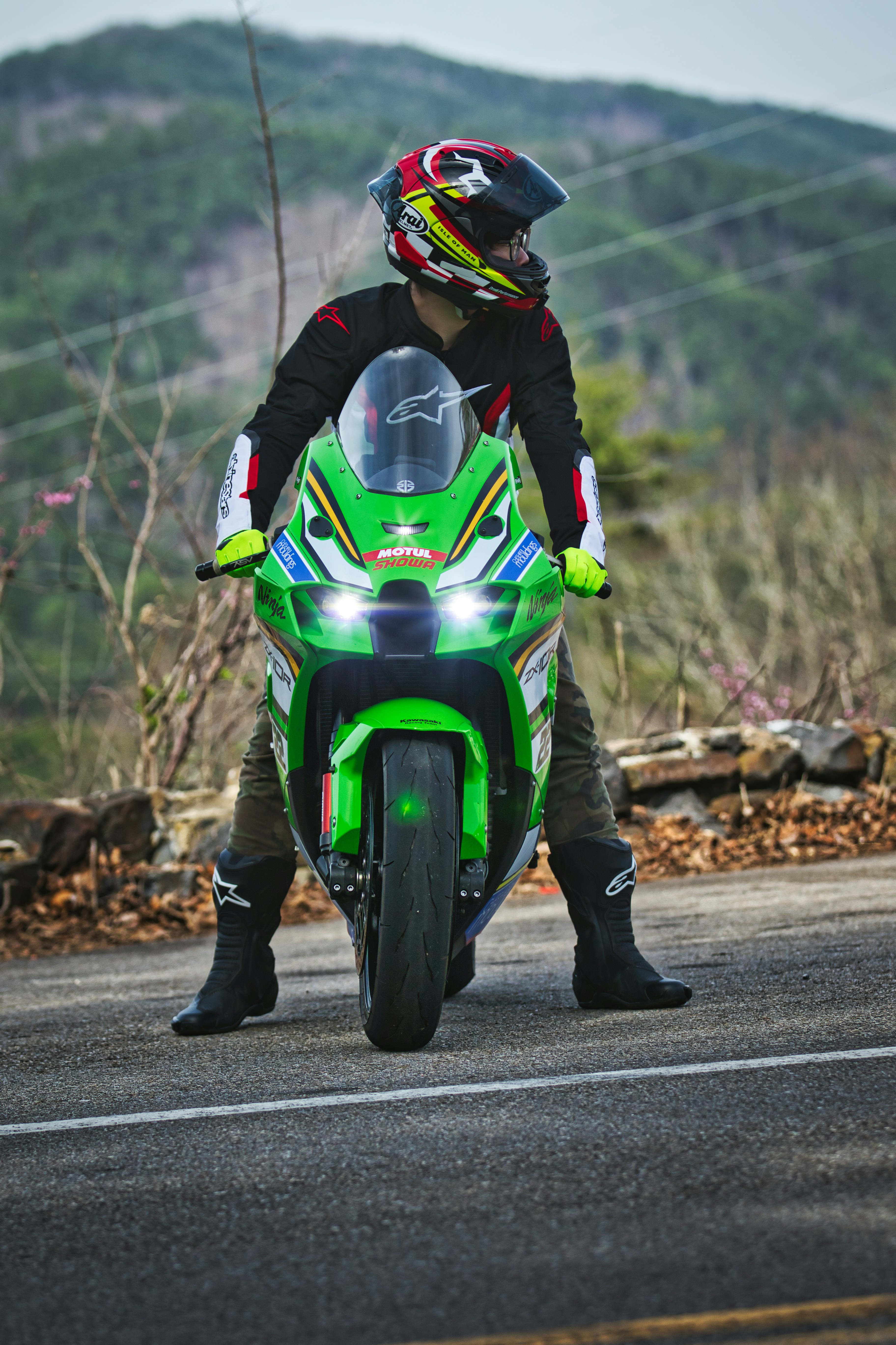 Rider on a green sport motorcycle on a road