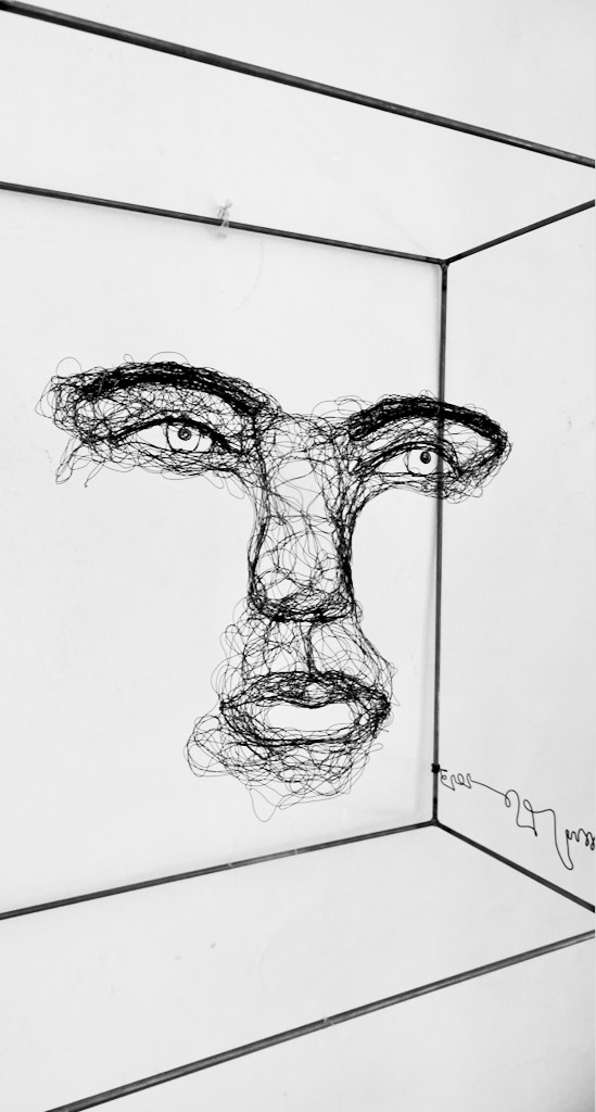 Sculpture en fil de fer représentant le visage d'une femme dans un cadre en fil de fer, vue détaillée de profil