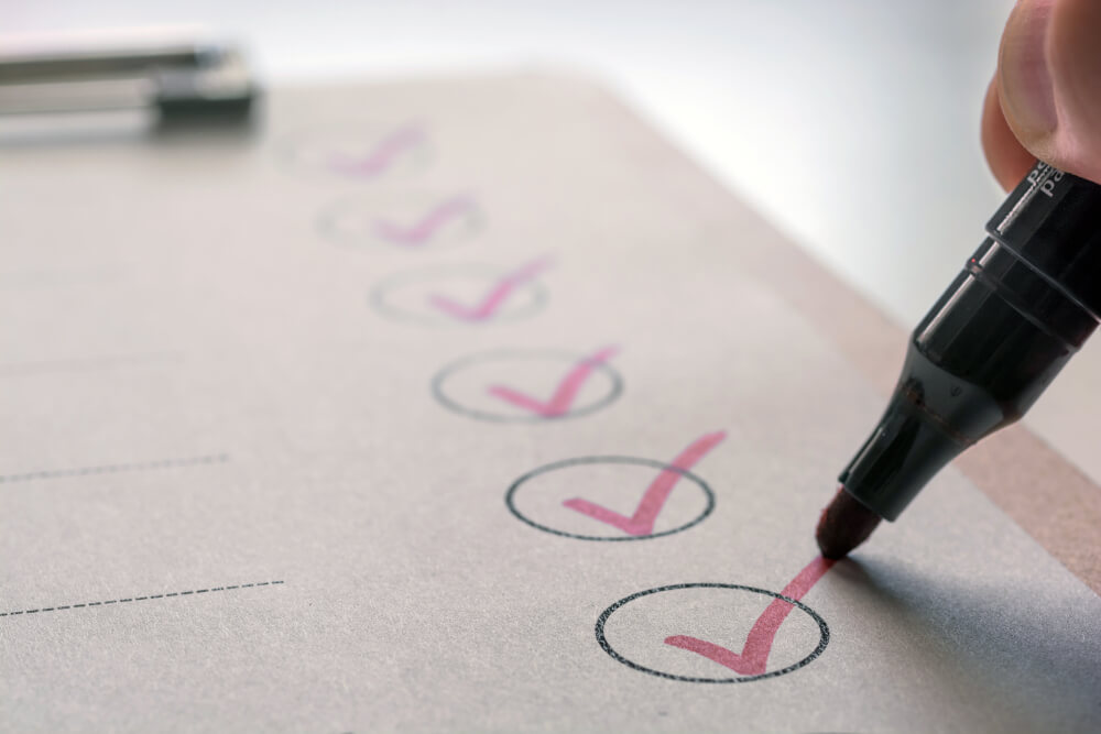 A person signing a document on a table, with a focused expression and a pen in hand. Form I539