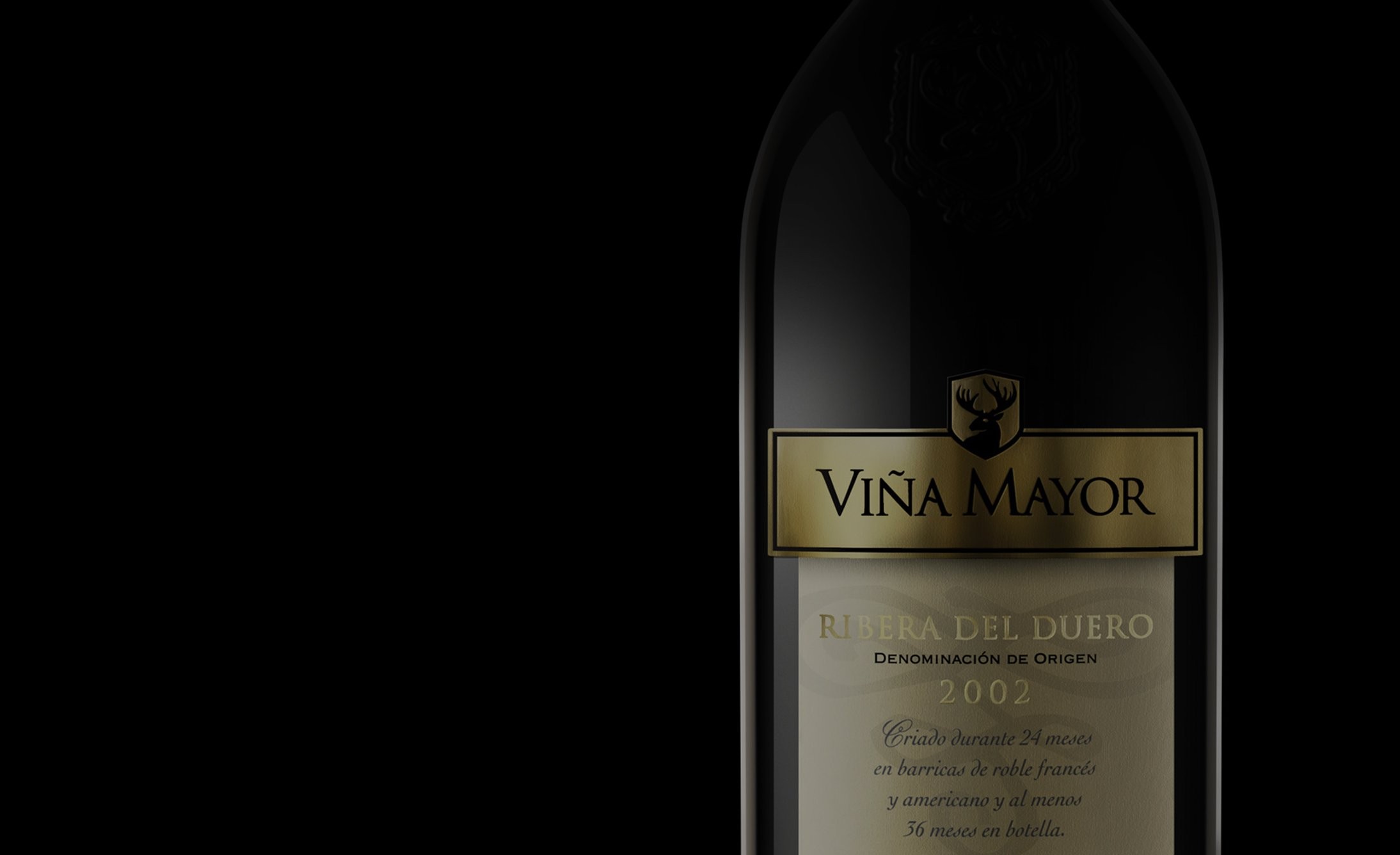 A dark wine bottle with a gold label reading "Viña Mayor" is partially visible against a black background. The design conveys elegance and luxury.