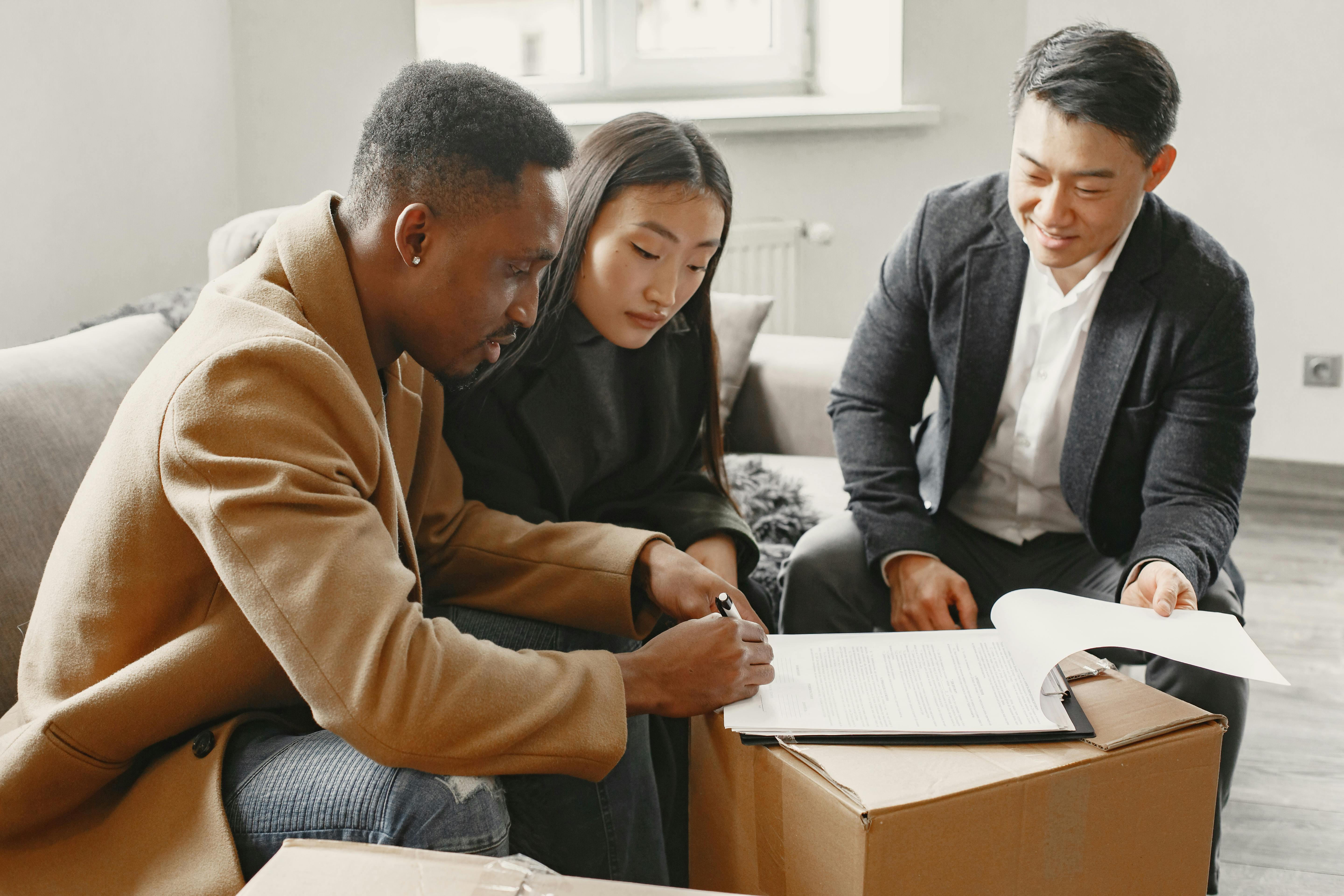 A man and a woman signing papers with a property agent