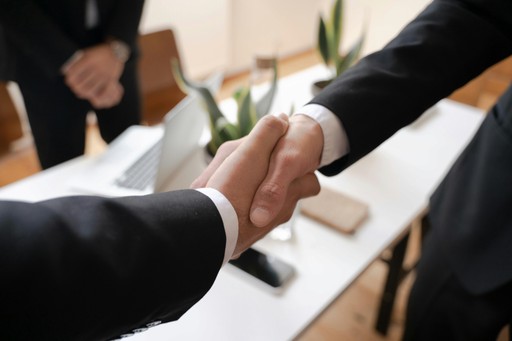 Closeup of business handshake symbolizing partnership, trust, and onboarding with EU compliance experts.