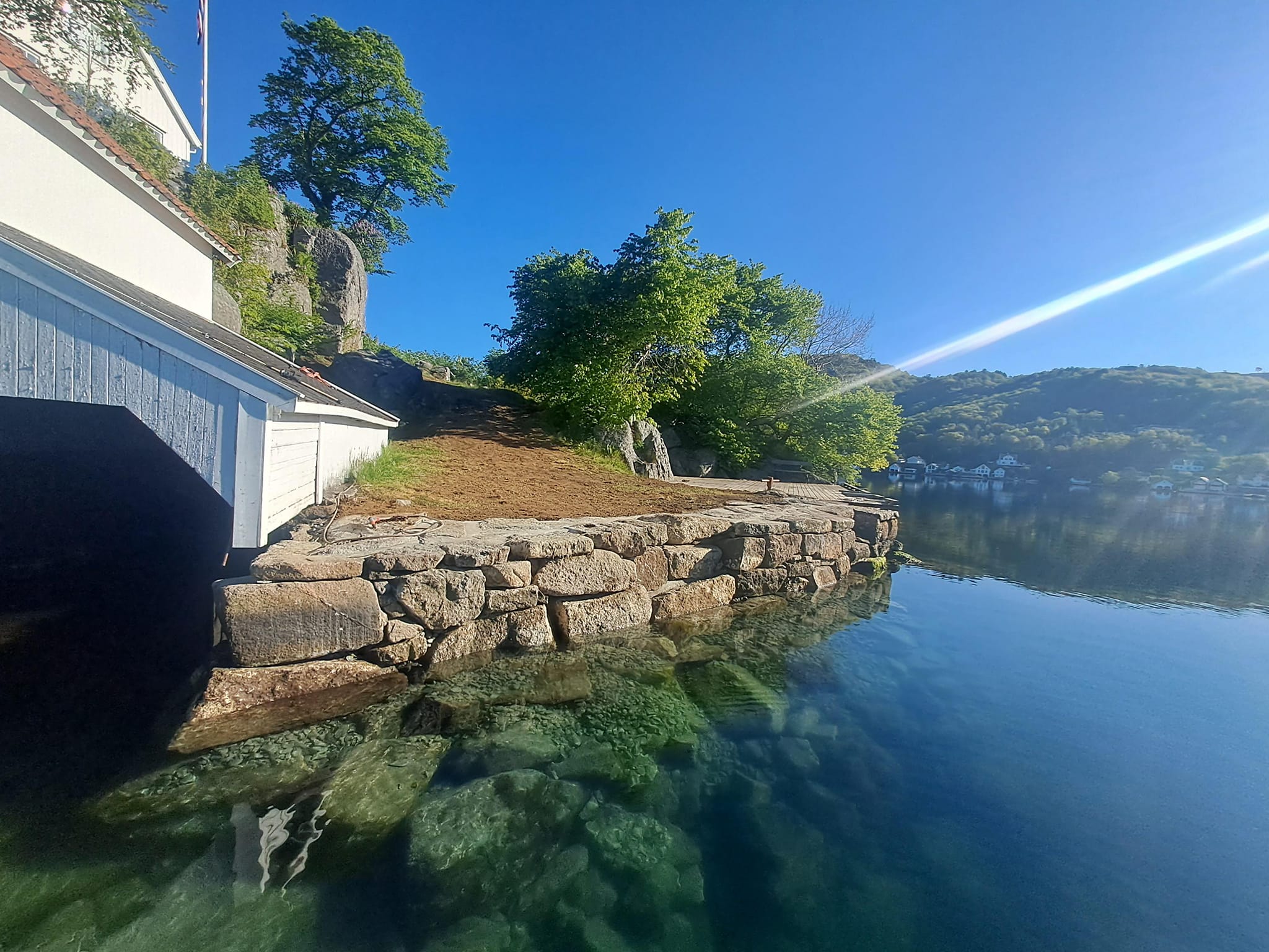 Steinlagt mur ved vannkanten.