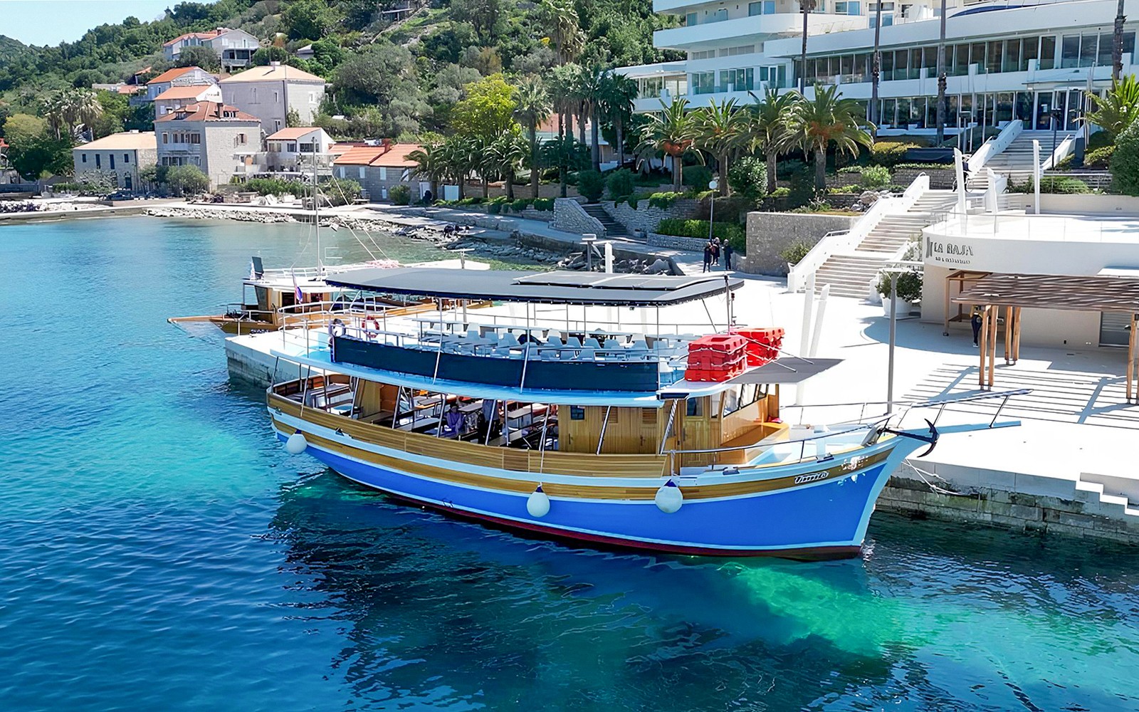 Boat docked along the shores of Elaphiti Islands with coastal buildings in the background.
