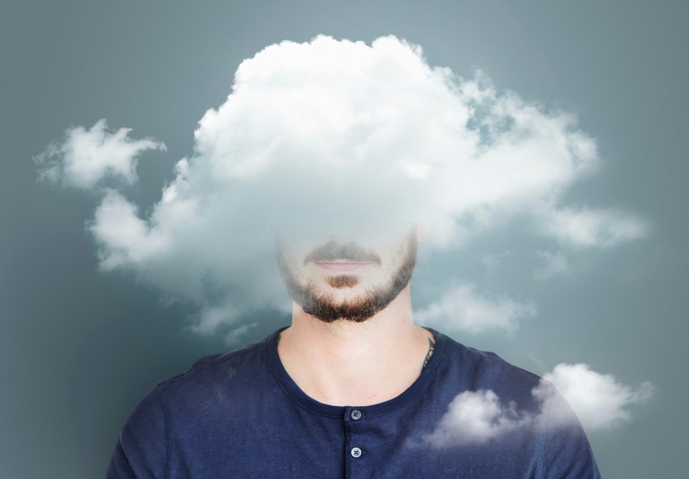 A man with his head obscured by clouds, symbolising confusion and struggles with mental health