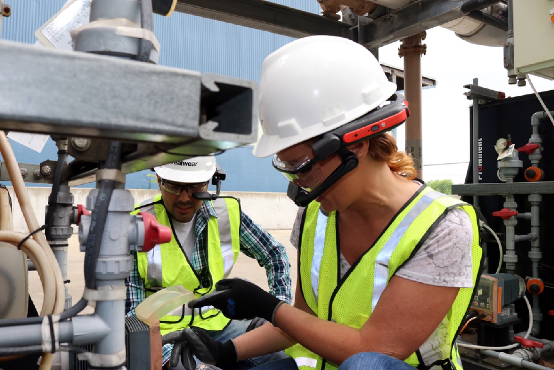 A photo of 2 industrial engineers wearing RealWear Z1 headset at work