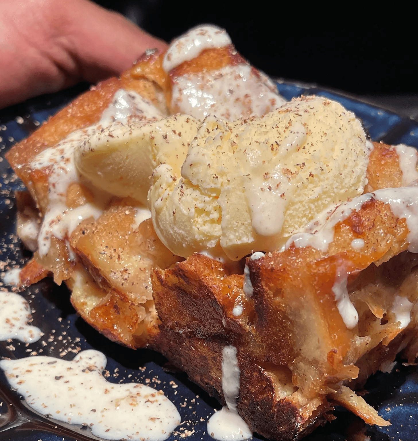 golden-brown, moist bread-pudding with vanilla ice cream melting over the top