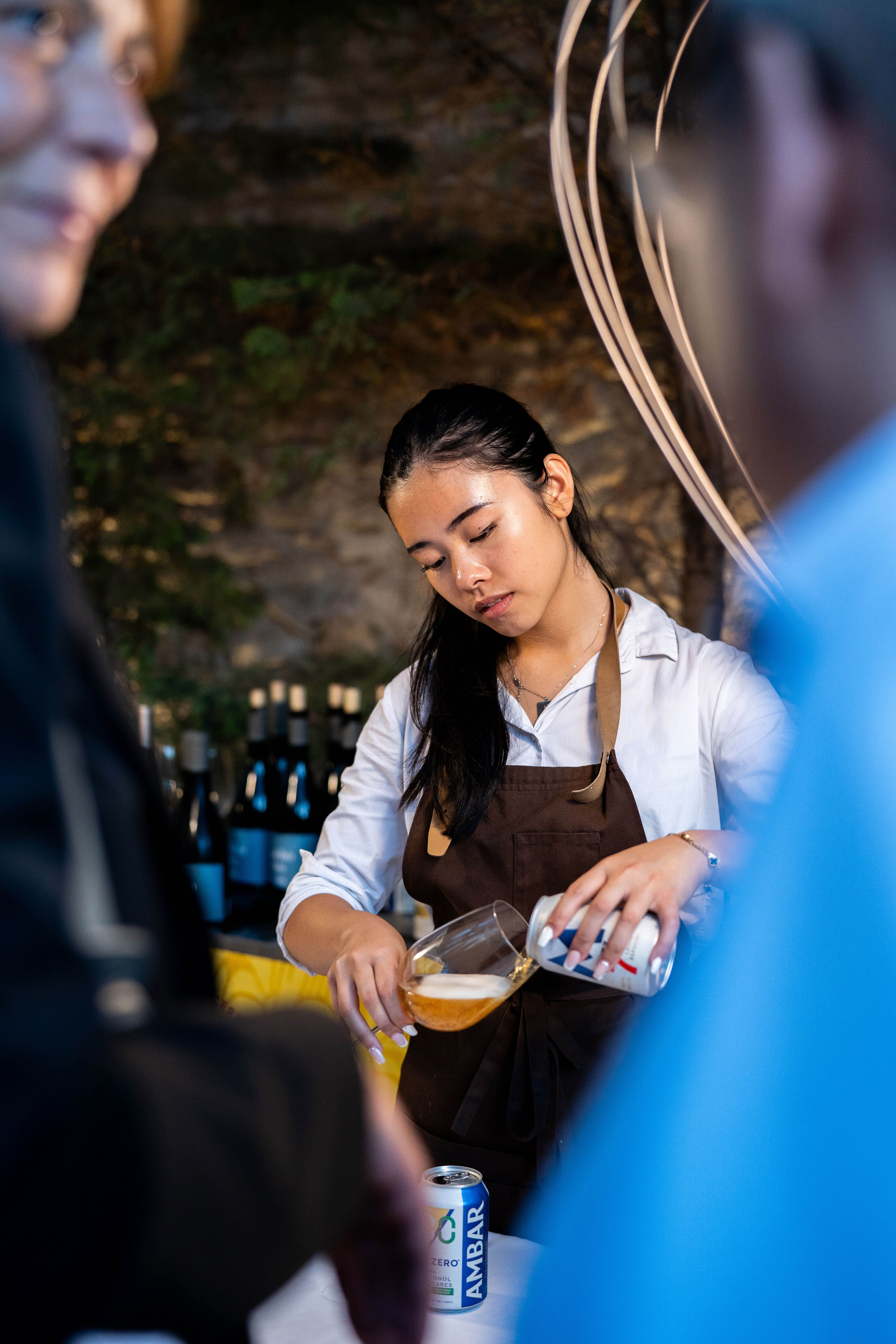 Camarera sirviendo una cerveza Moritz en una copa
