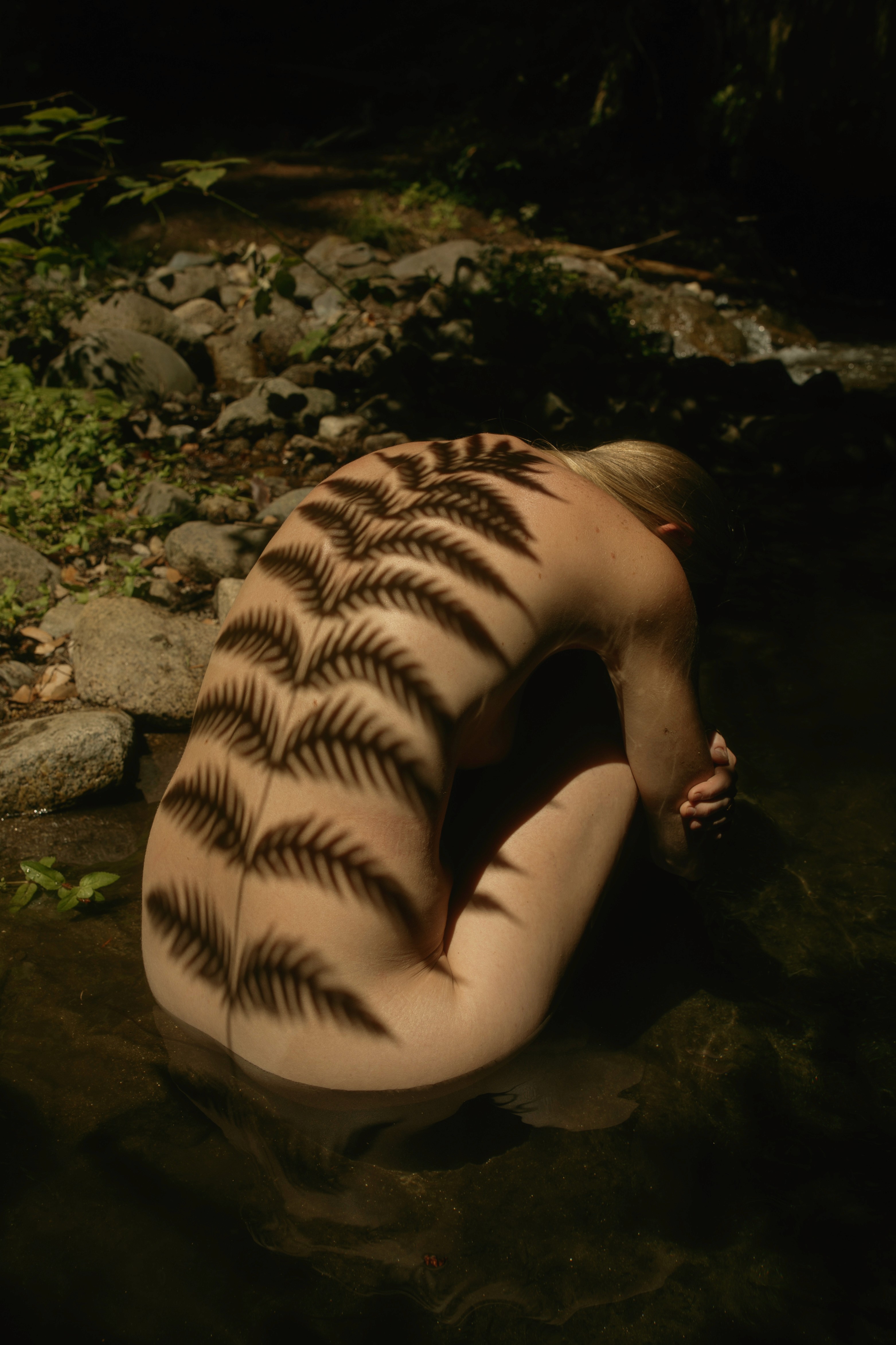 Sonia performing a smoke cleansing ritual in a sunlit jungle during a sacred plant medicine ceremony