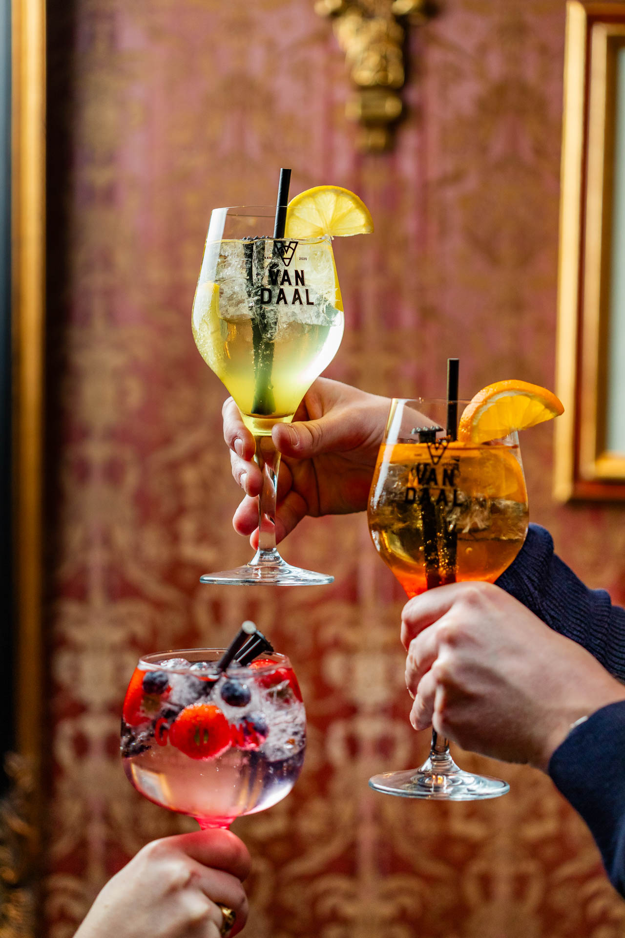 drie handen met een cocktail in de hand, ze proosten