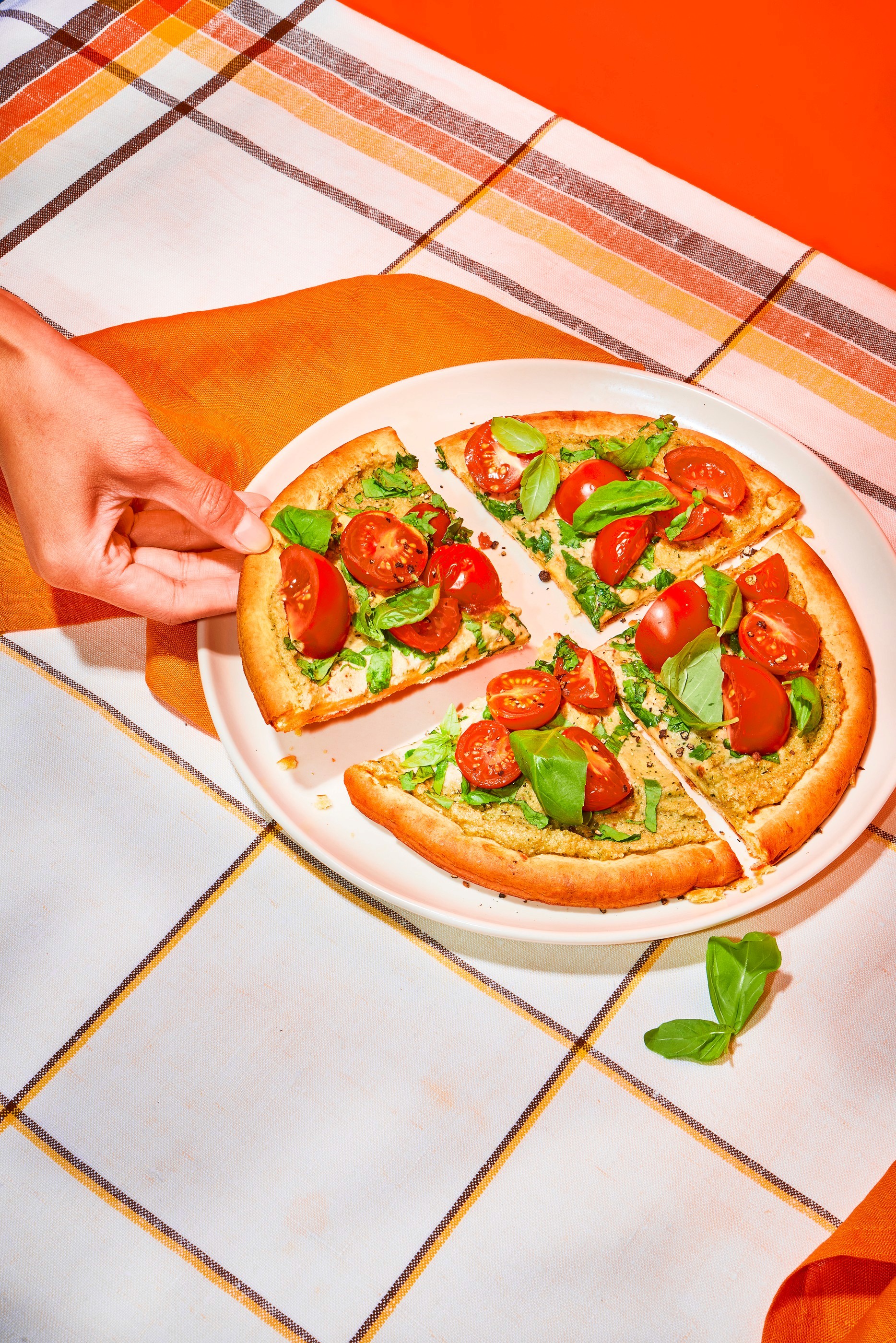 Tomato pizza, hands in frame