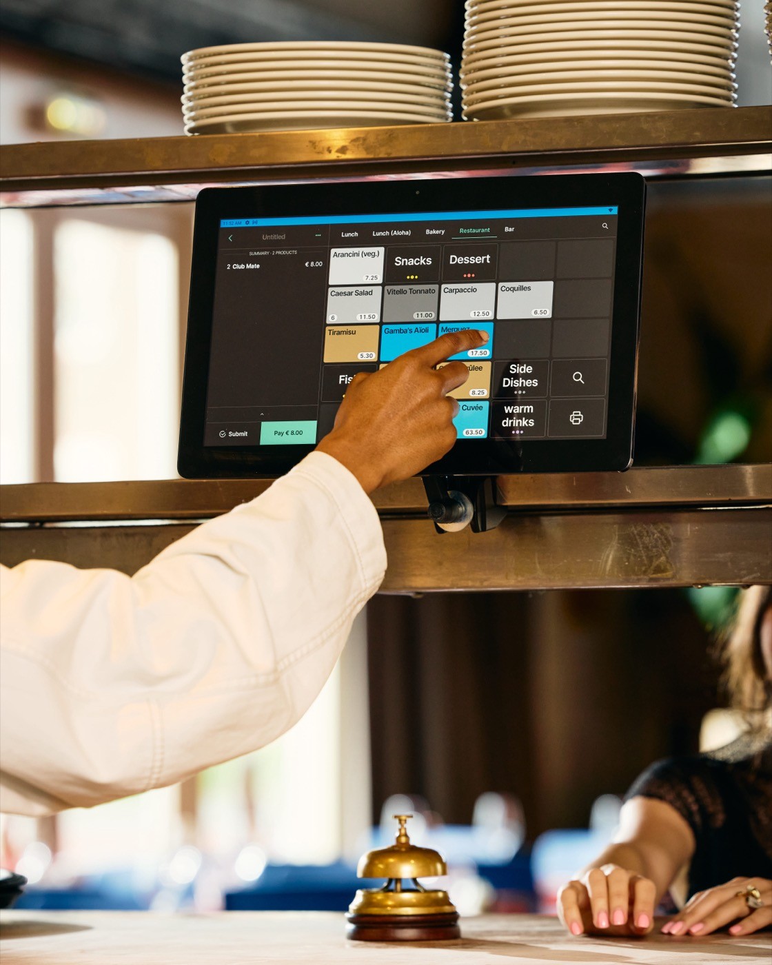 Tebi Pos in a restaurant kitchen and somebody is interacting with the screen