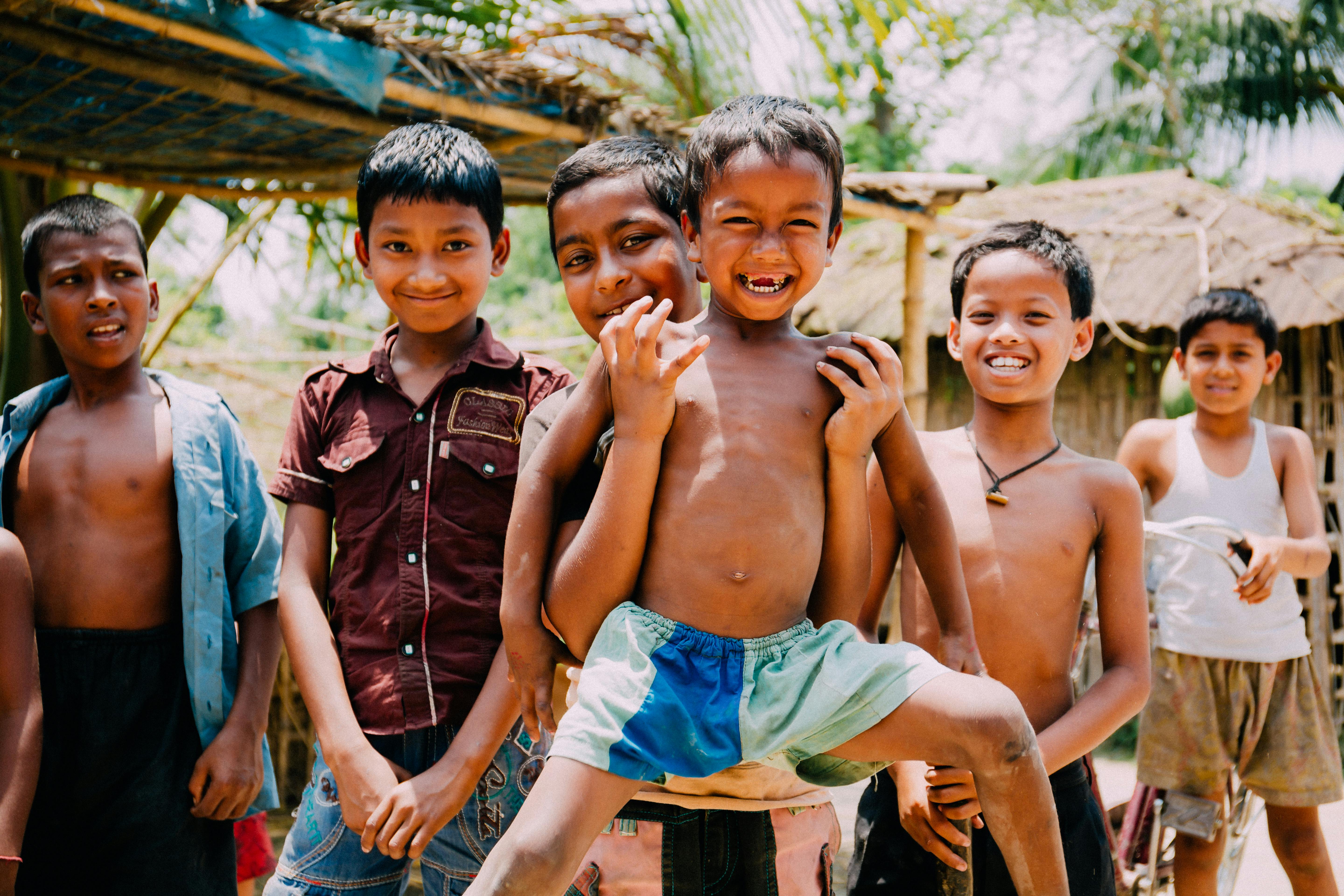 five children smiling while doing peace hand sign
