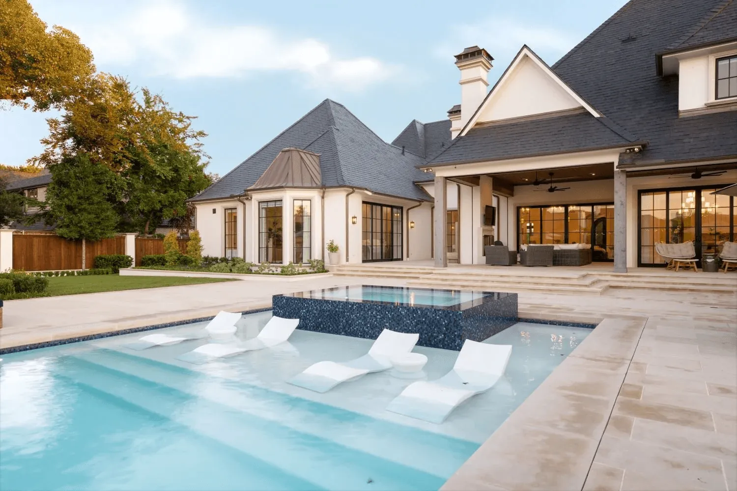 Custom negative edge spa with dark mosaic tile and resort pool for Preston Hollow Dallas estate by Blount Designs