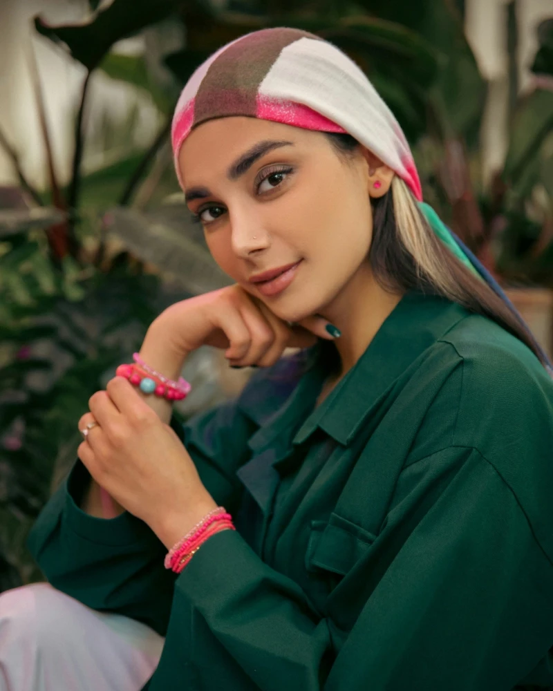a man in a black hoodie standing in front of a tree