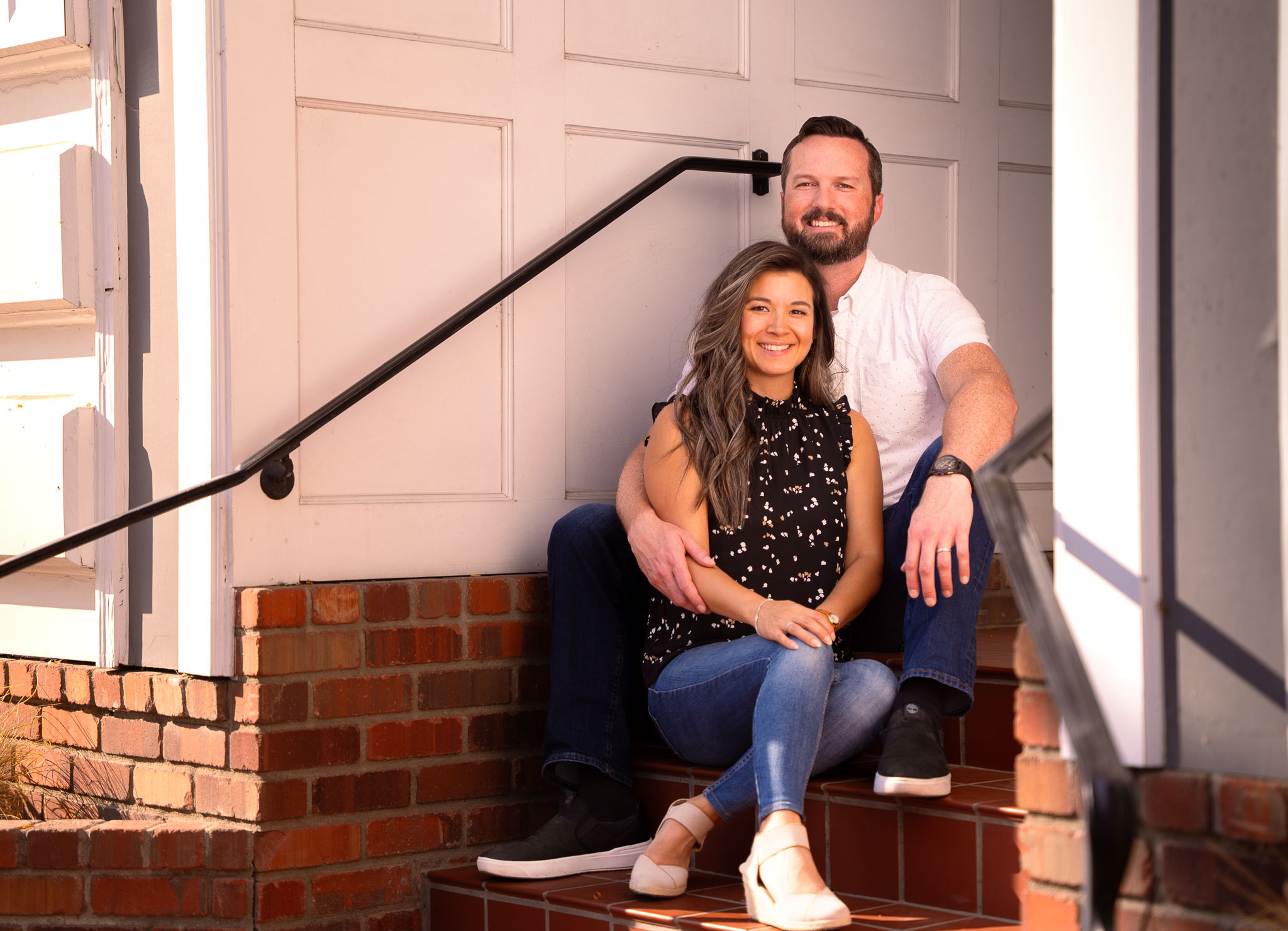 a woman sitting next to a man on a staircase made of brick
