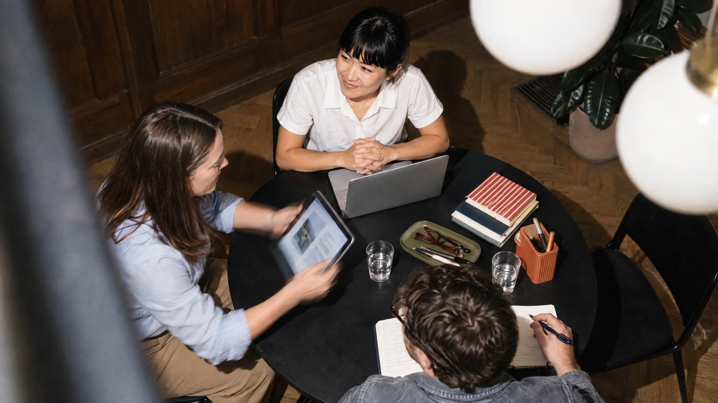 Flexiti colleagues meeting around a table with laptops and a tablet