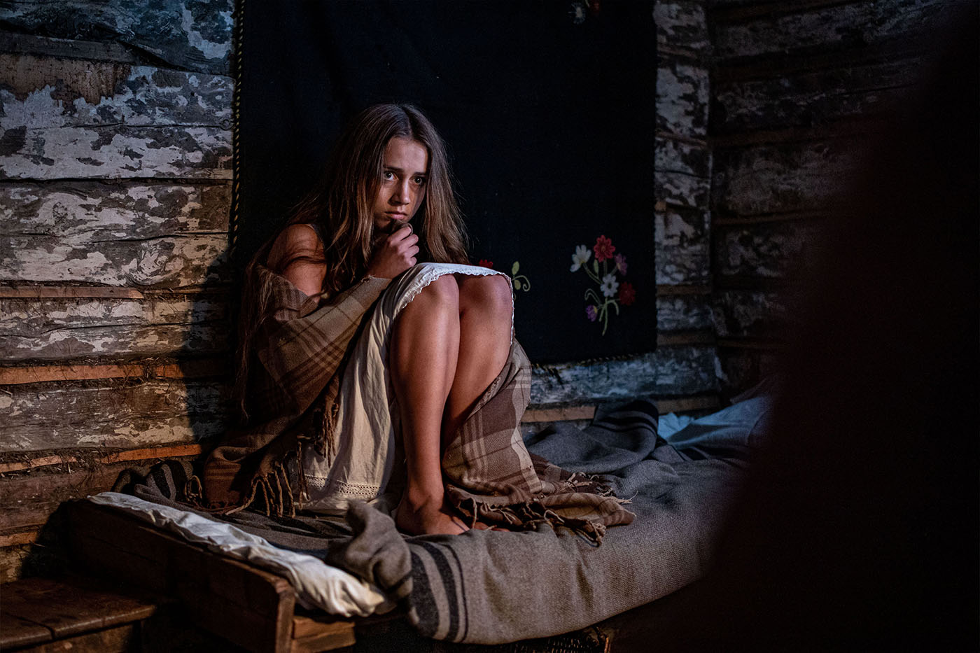 Scene from the Bog, where the main female hero is sitting on the bed