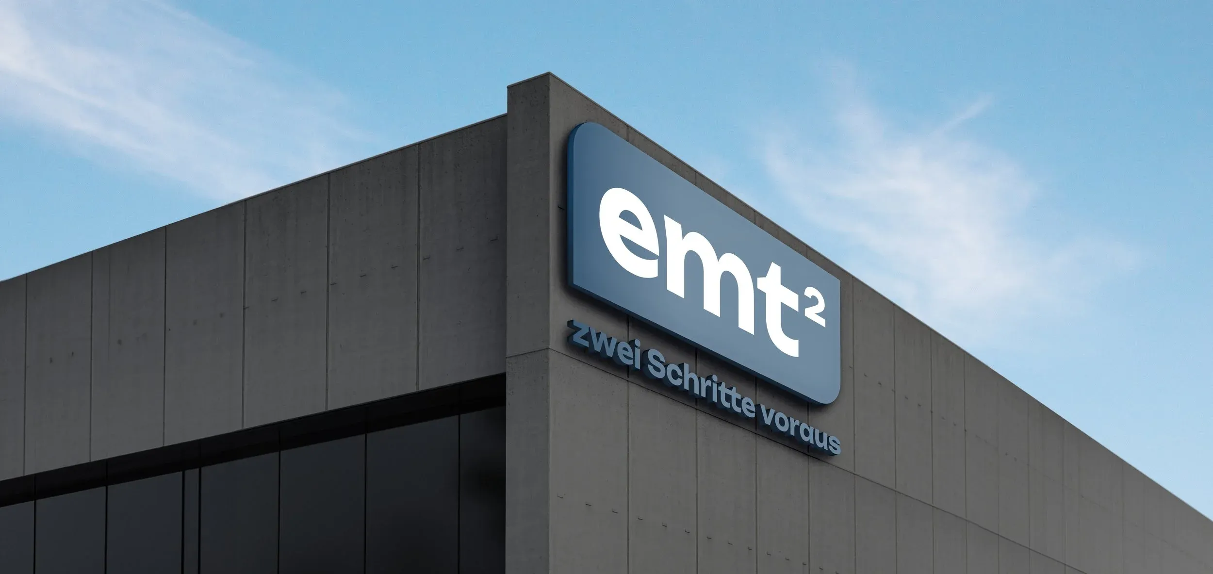 EMT² Logo auf einem modernen Gebäude: Zwei Schritte voraus.